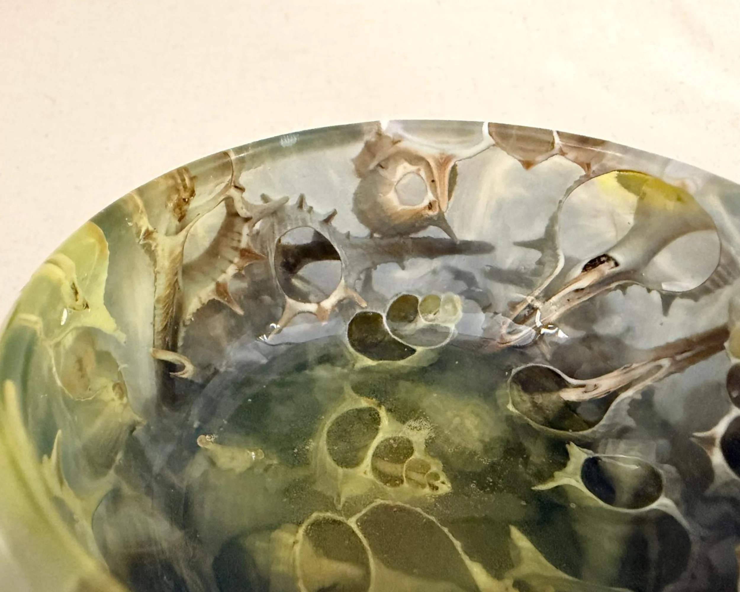 Side close-up of green-blue resin vessel showing real seashell inclusions and polished glossy finish.