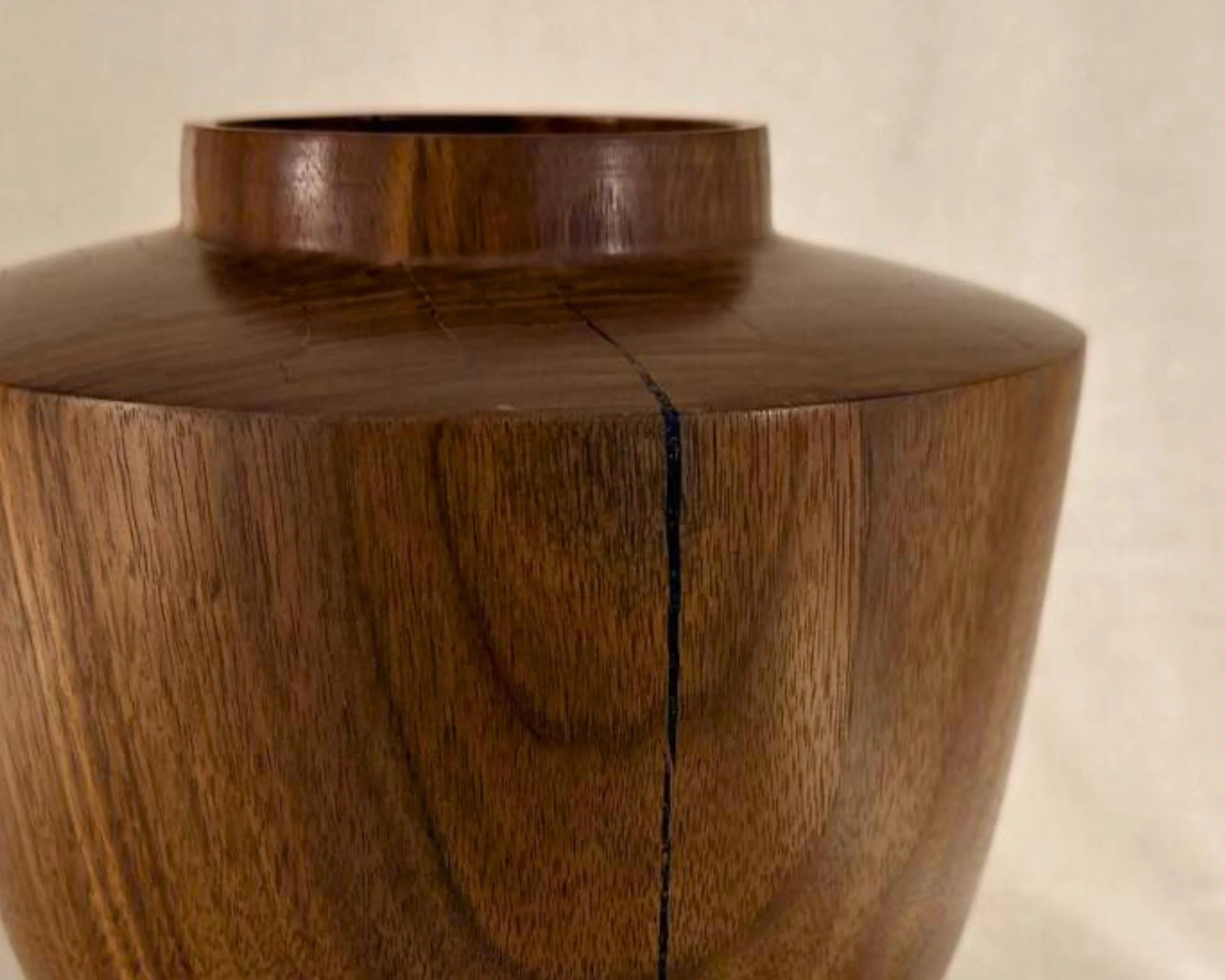 Close-up of black epoxy-filled vein in walnut, showing the contrast between dark epoxy and warm grain.