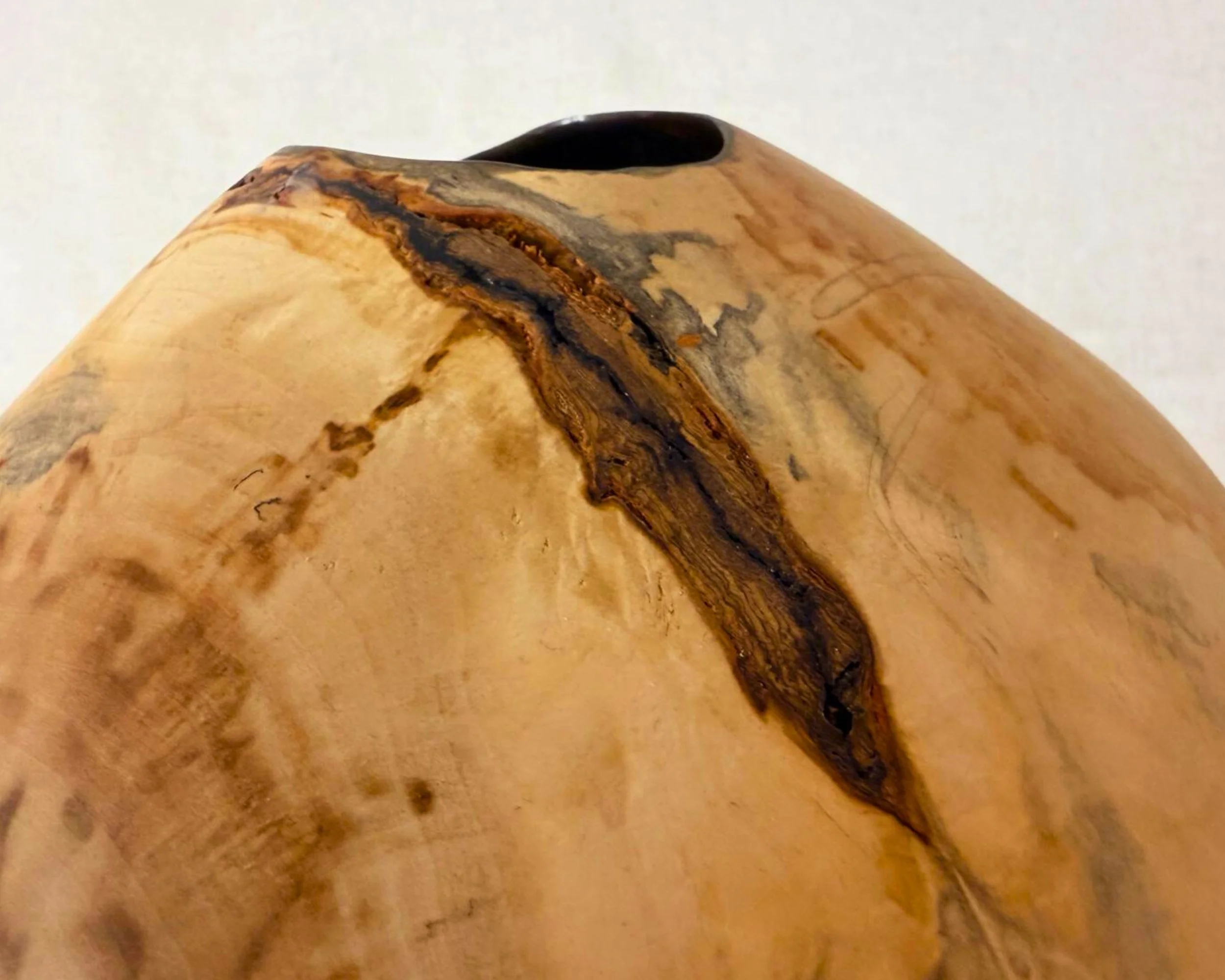 Detail view of rim area showing a dark inclusion line and the transition into the black epoxy-coated interior.