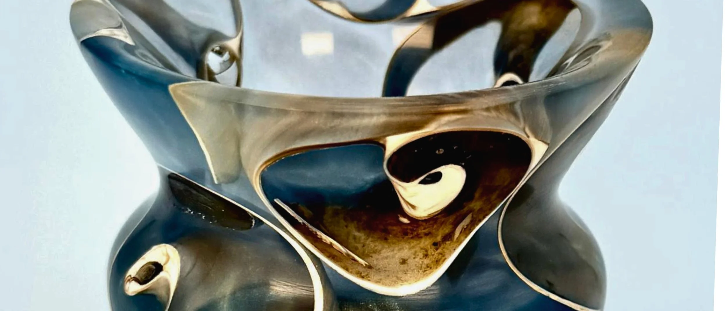 Close-up of a handturned epoxy sculpture with real seashells encased in swirling blue resin.