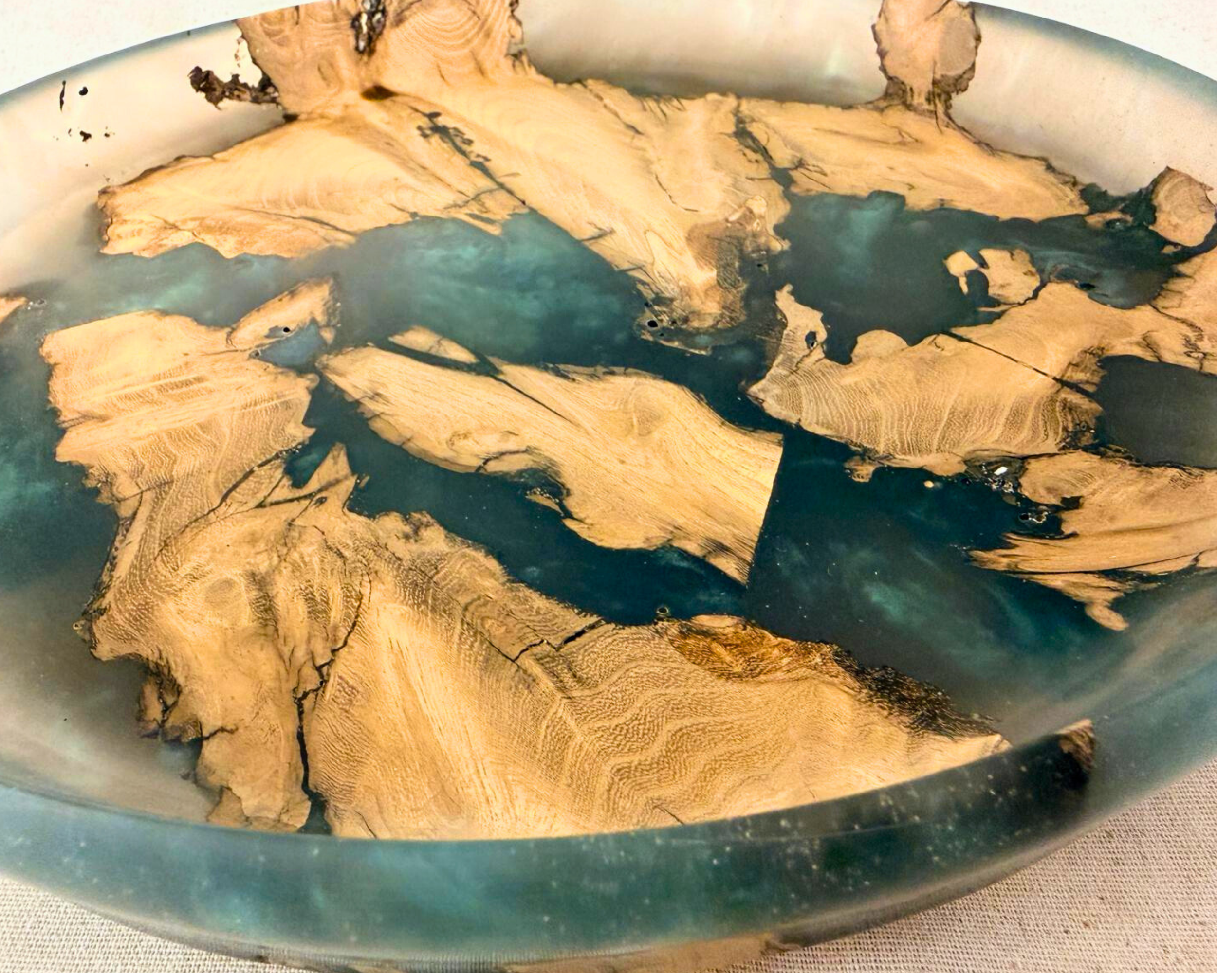 Close-up of tree root wood grain within epoxy platter showing natural texture and tonal variation.