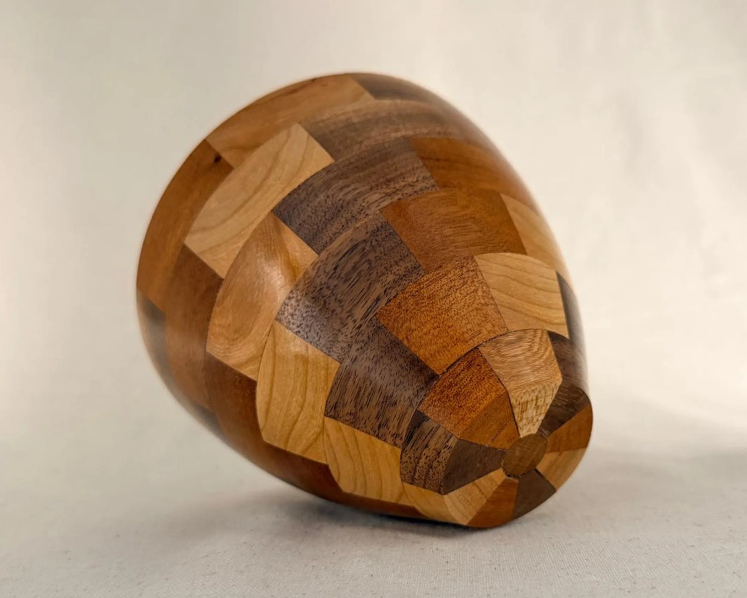 Bottom angle view of segmented vessel showing patchwork layout and tapered base.