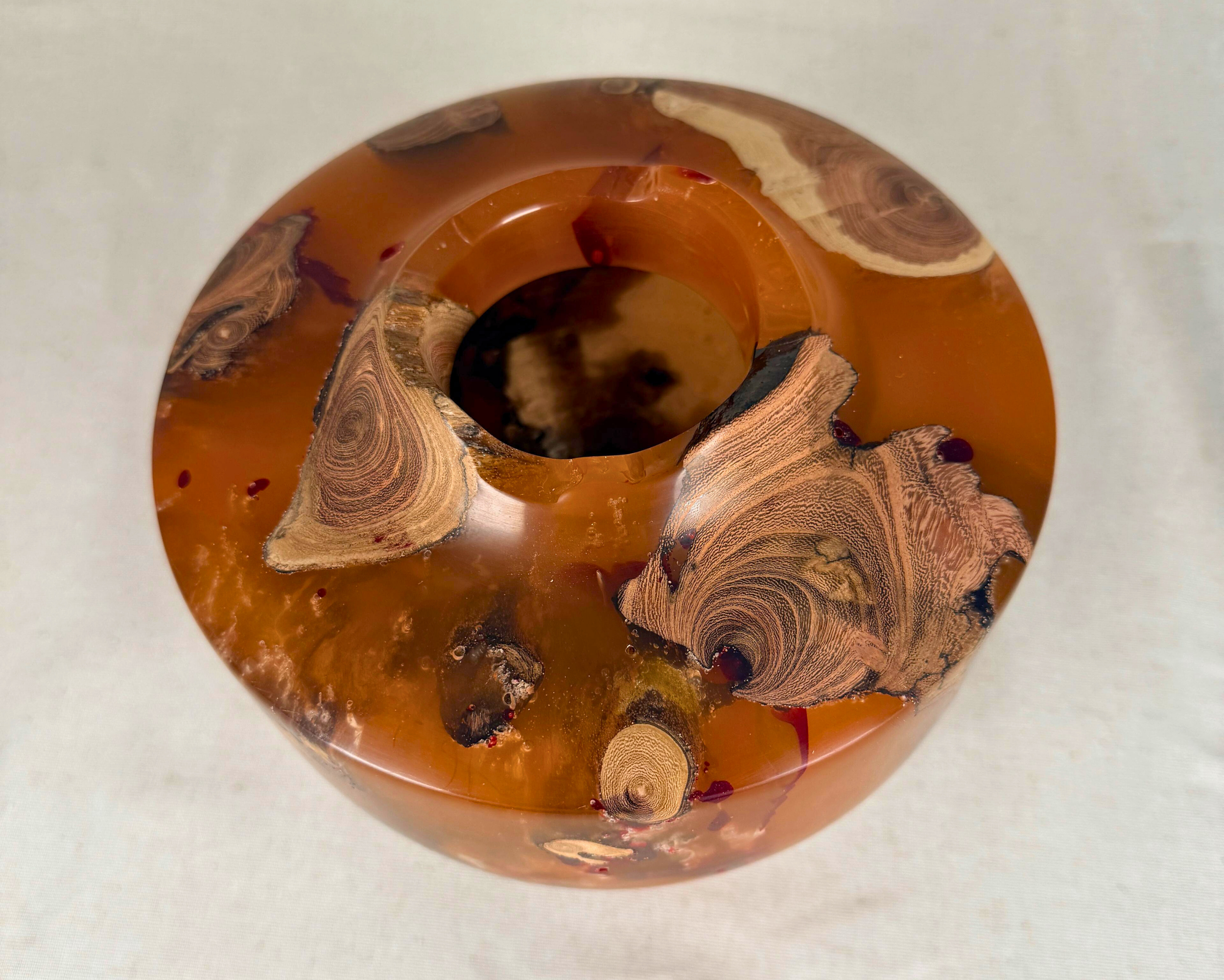 Overhead view of the vessel showing the 2.5-inch opening, asymmetrical sculptural rim, and driftwood inclusions set within translucent amber and ochre epoxy.