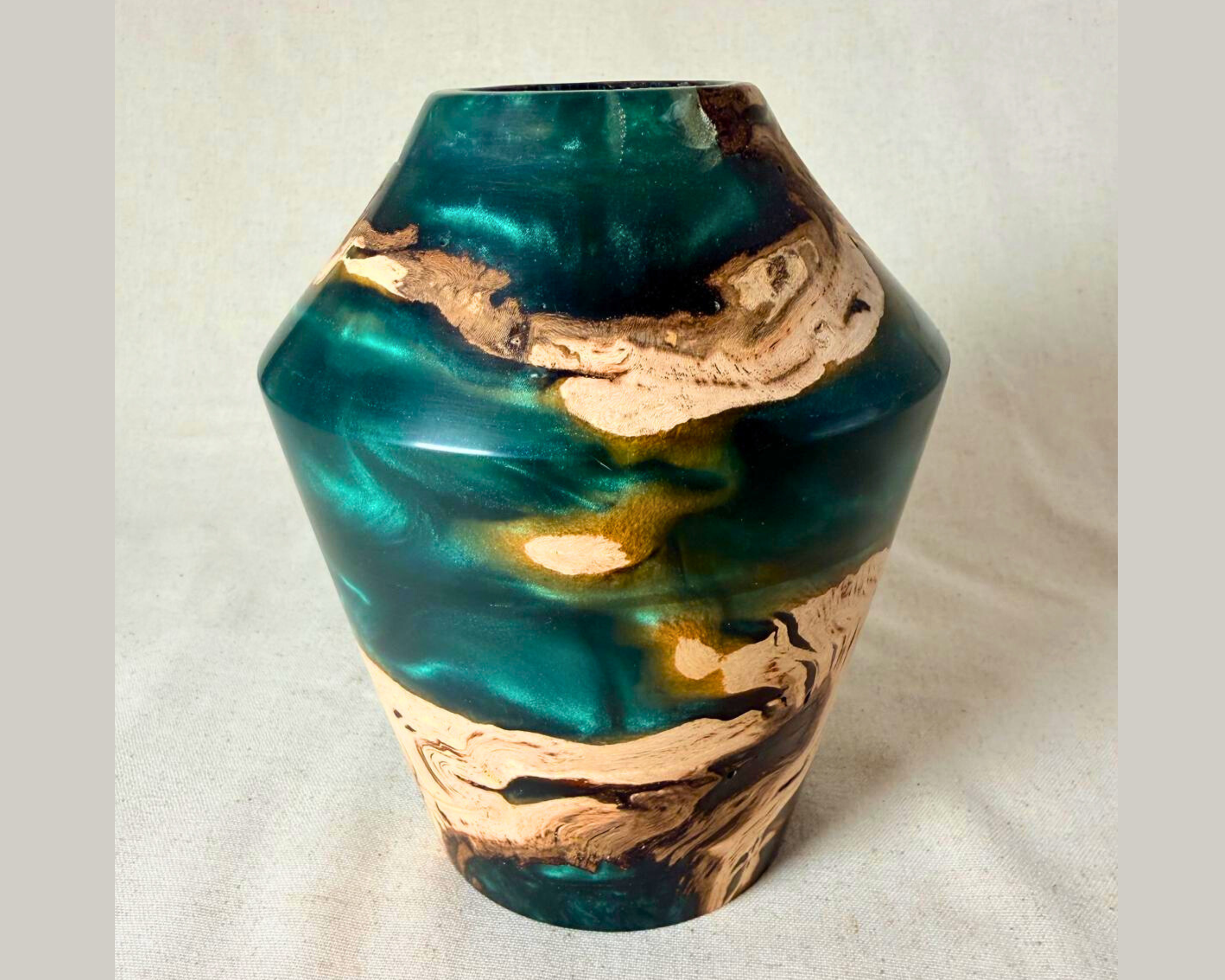 Side view of driftwood and green epoxy vessel with narrow opening, sculptural silhouette, and vivid green resin contrasted by raw-looking driftwood figure.