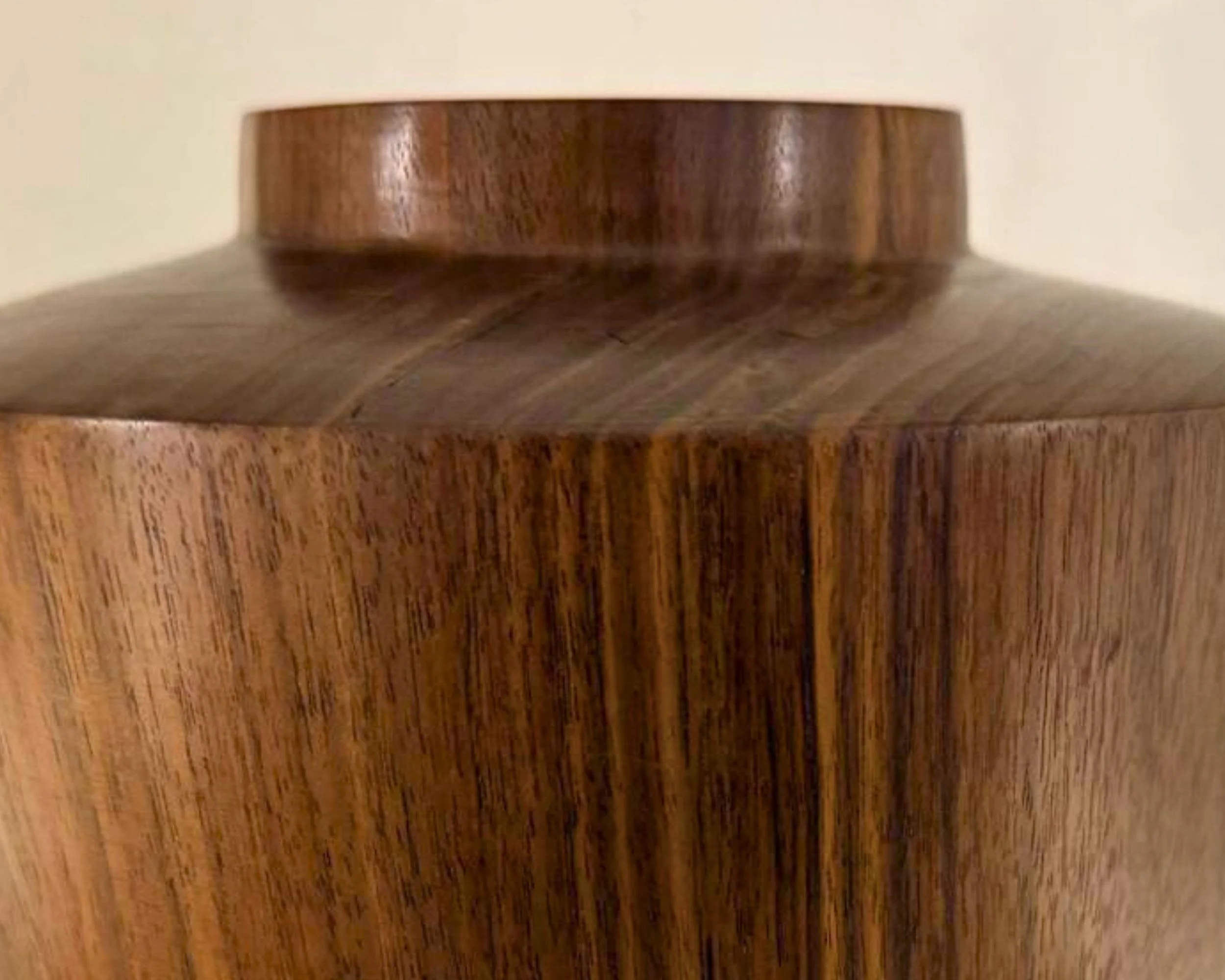 Close-up of a wooden container with a rounded top and smooth grain pattern.