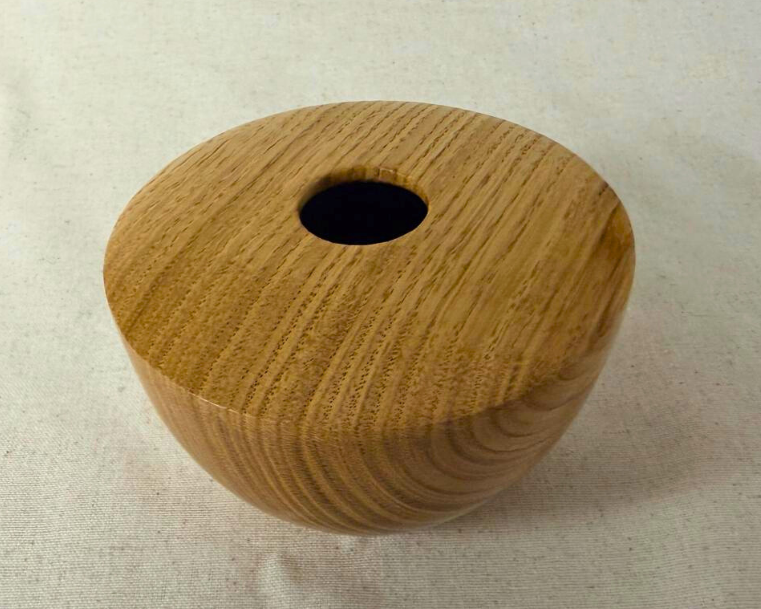 Top-down view of the oak hollow form showing the opening and broad grain lines across the surface.