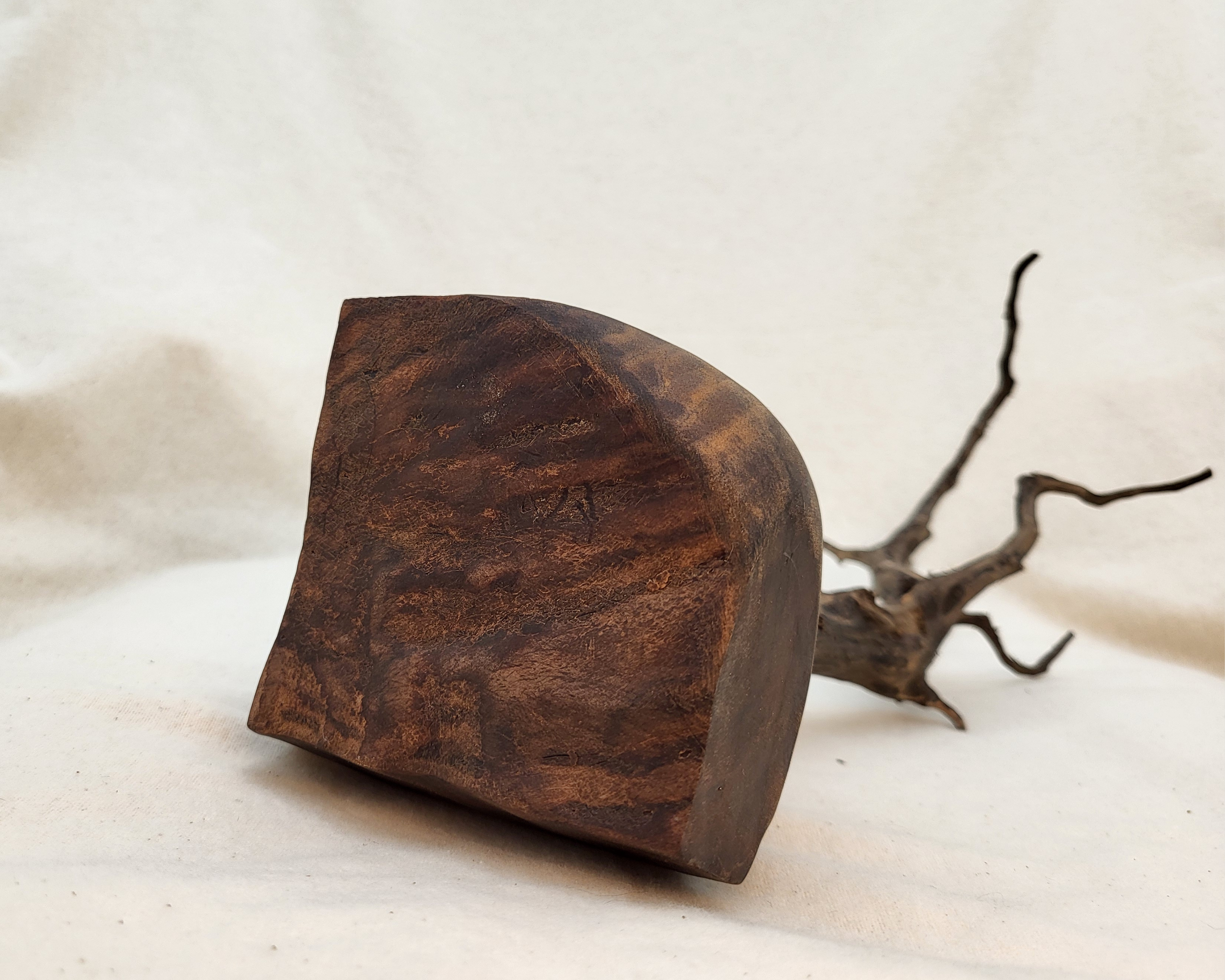 Underside view of the claro walnut base on a sculptural driftwood and walnut piece by Treverk Woodturning, showing the irregular wedge-shaped footprint and rich claro grain in matte finish.