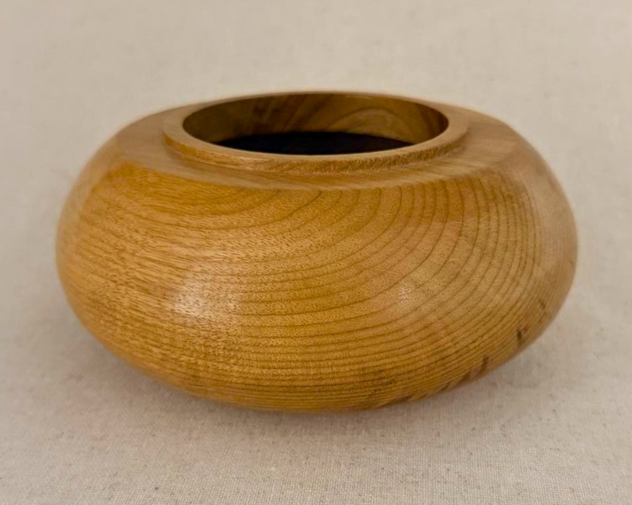 Side view of a compact myrtle vessel with a broad rounded form and gently elevated rim.