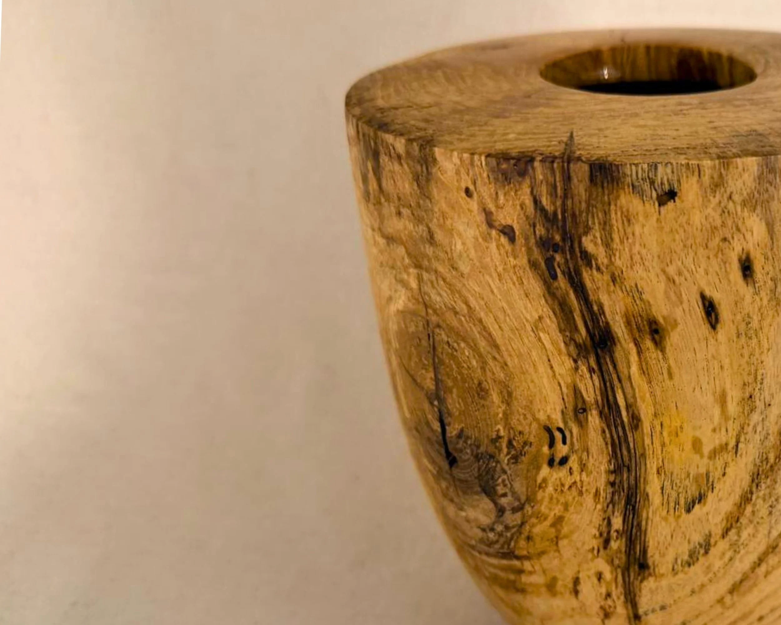 Close crop of the maple vessel’s side showing subtle spalting and natural markings near the upper rim and opening.