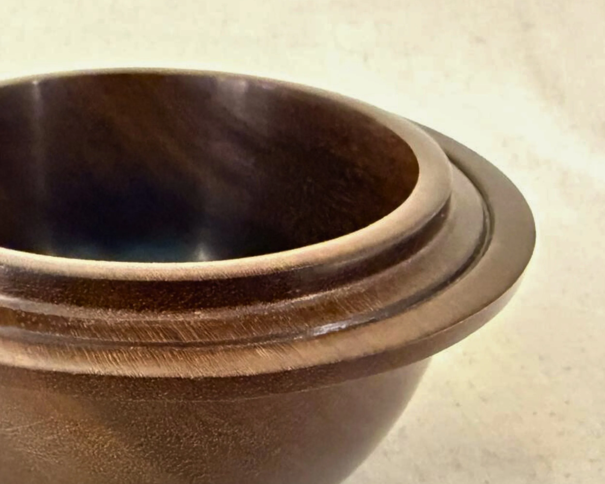 Close-up of rosewood bowl rim and interior showing satin finish and stepped lip.