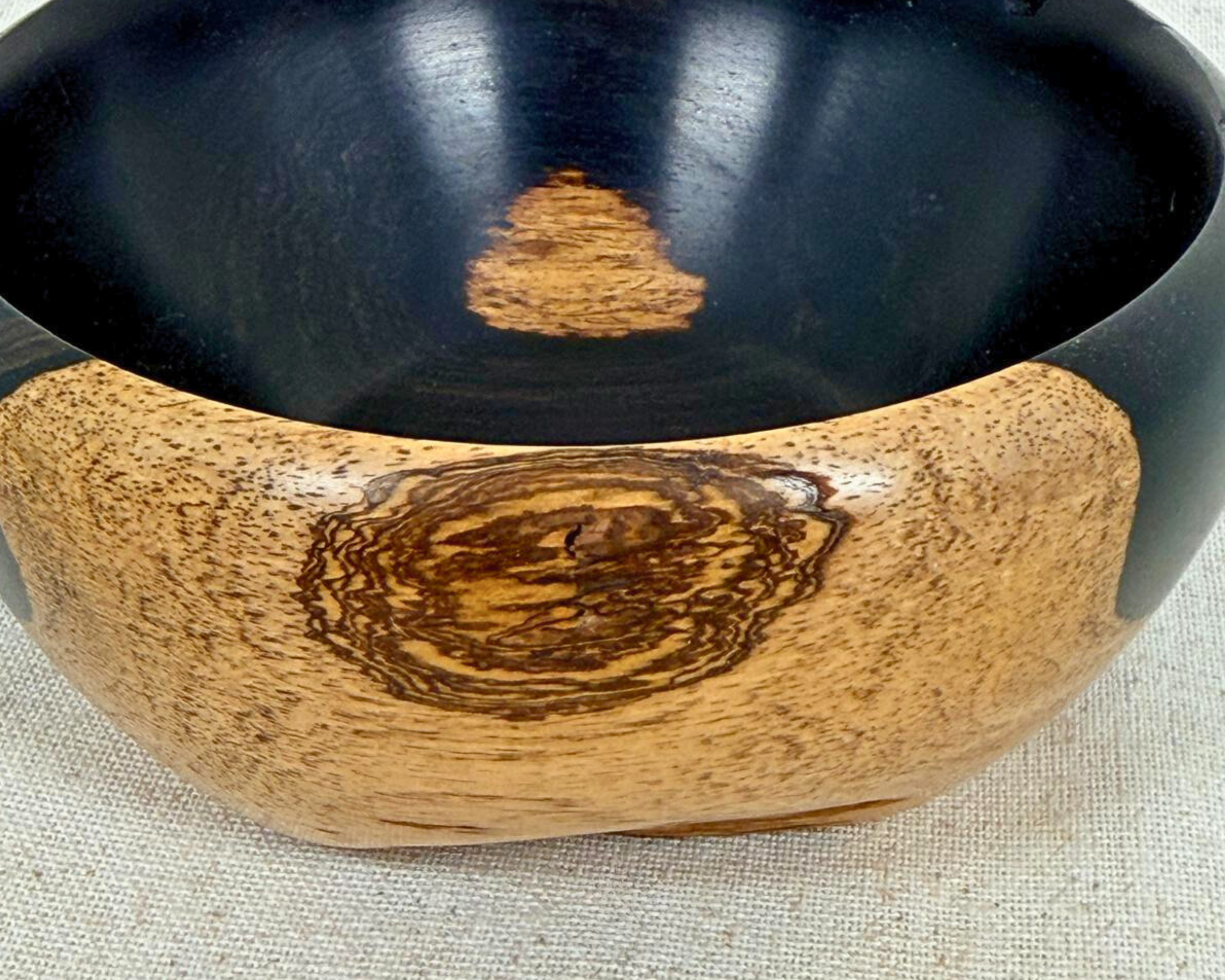 Close-up side detail of the African Blackwood bowl showing grain character, surface finish, and transition between dark and natural wood.