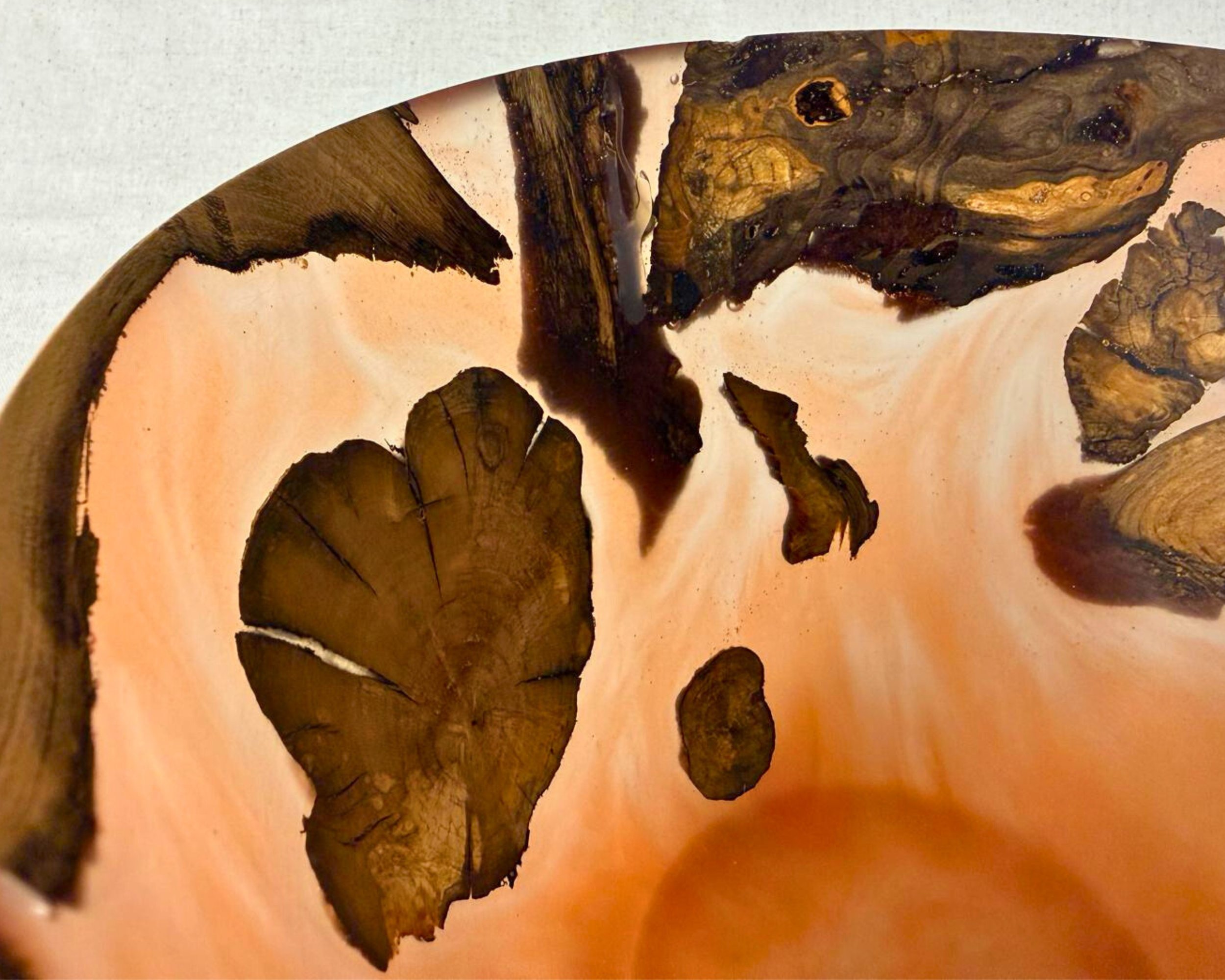 Interior view of the bowl with swirling amber epoxy and multiple embedded elm root fragments.
