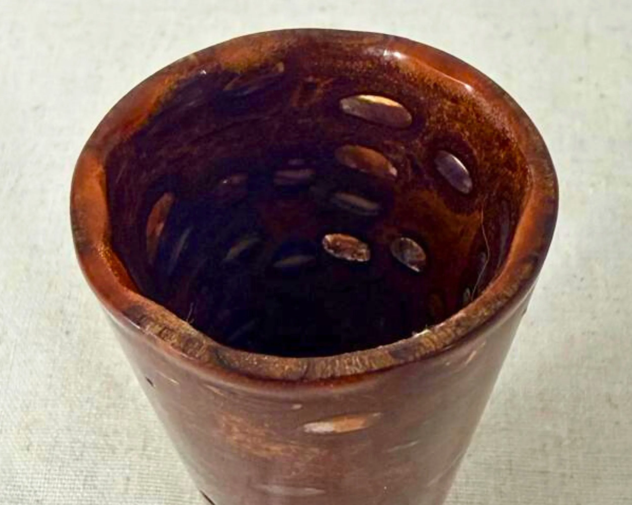 Close-up angled view of the vessel interior showing banksia void pattern and red epoxy fills along the inside wall.
