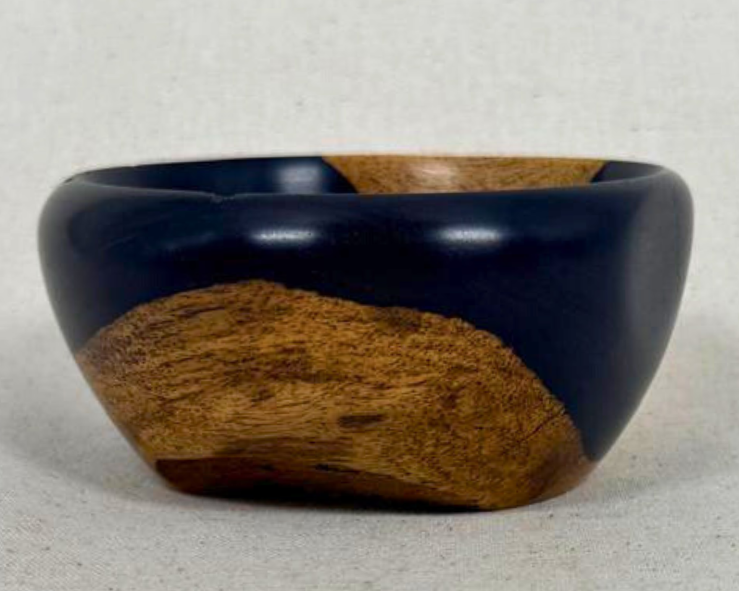 Side profile of the African Blackwood bowl showing the dark outer curve and rising asymmetrical form.
