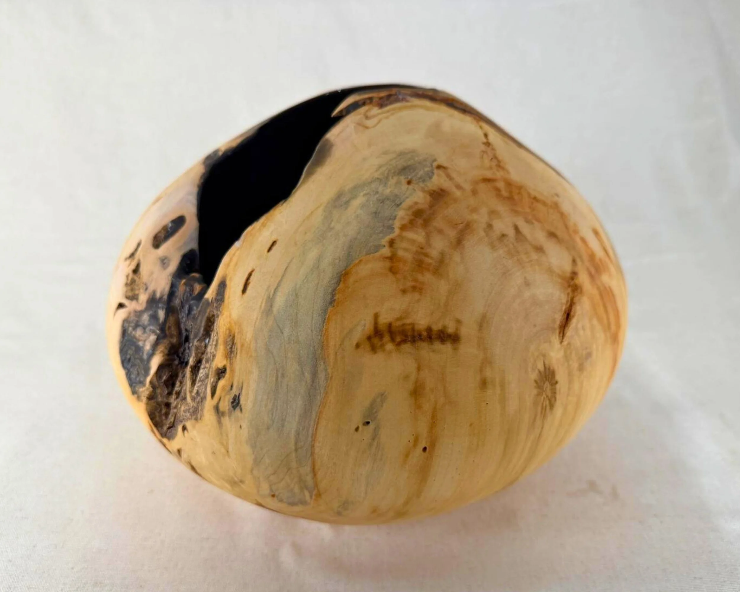 Top-leaning angle view of the reclaimed pine piece emphasizing the irregular opening and the matte-black epoxy interior.