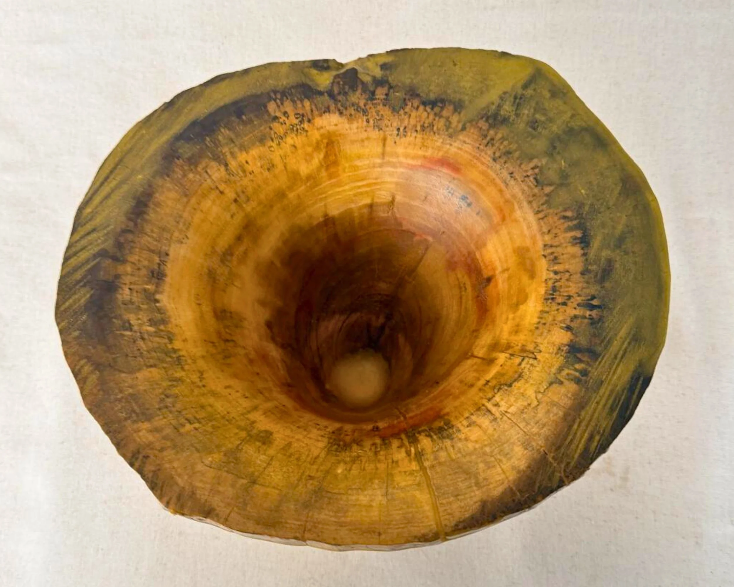 Top-down view into the vessel showing swirling interior grain and a wide natural-edge rim with multi-toned epoxy.