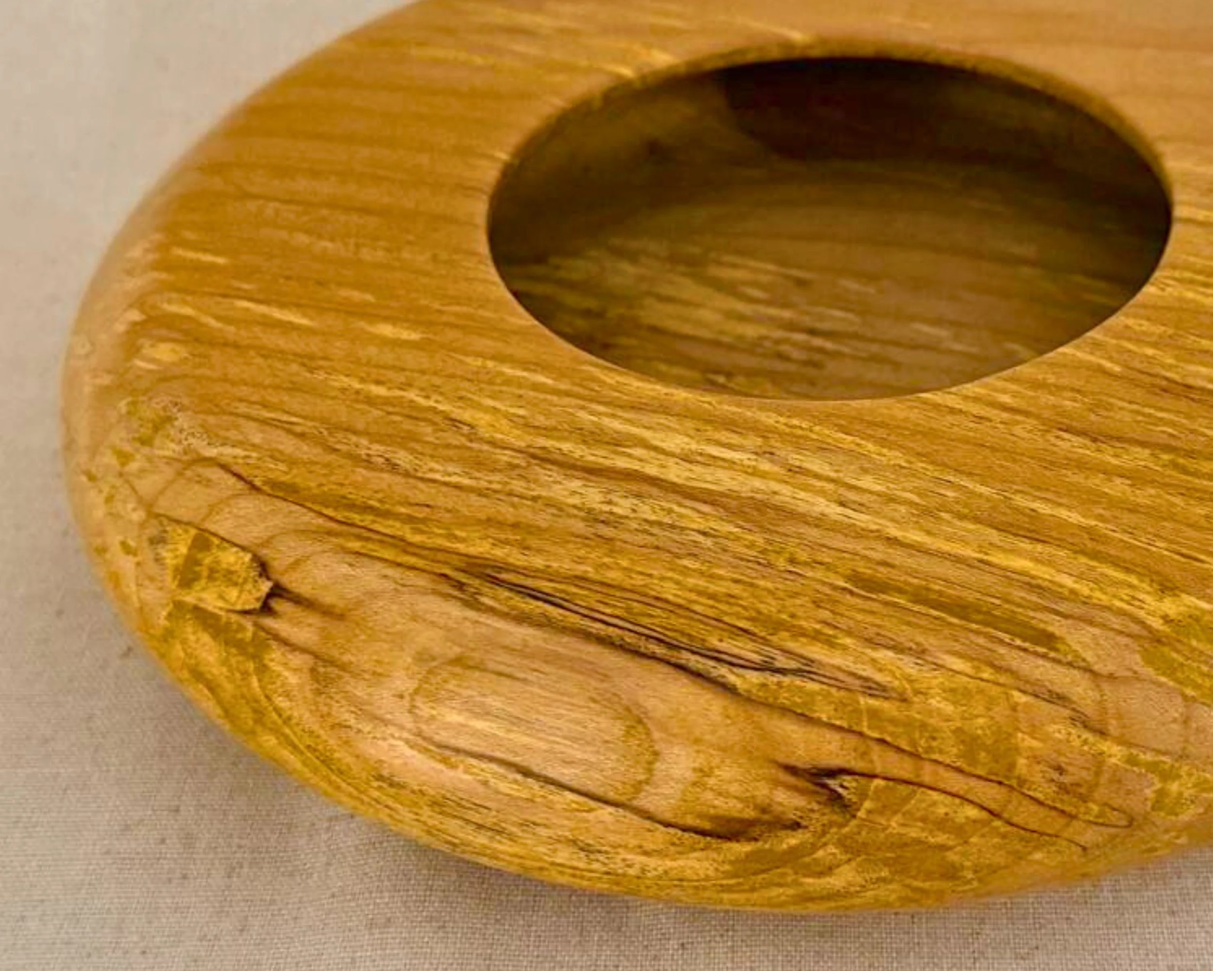 Angled close-up of the top surface of the figured maple closed form vessel showing figure and opening edge.
