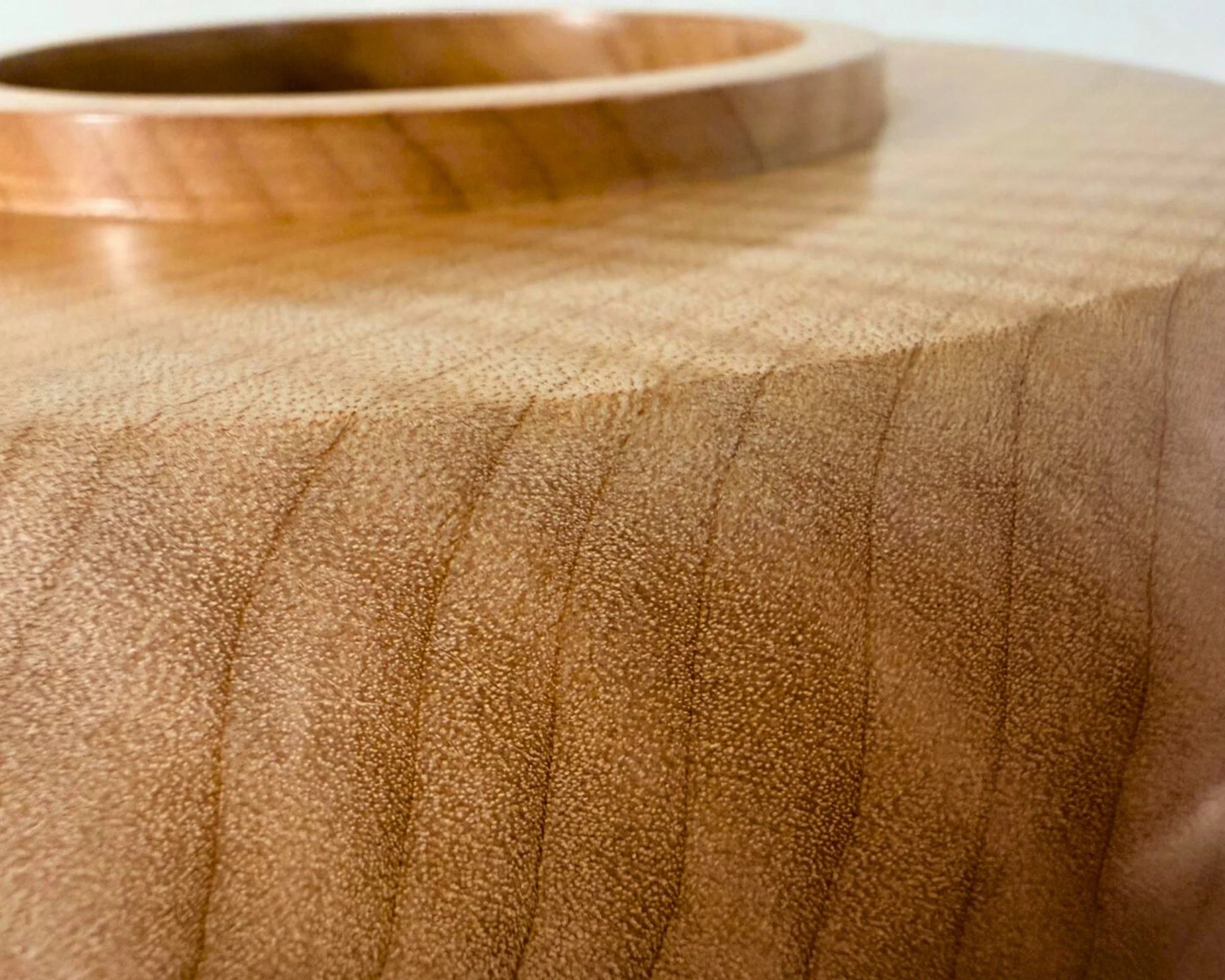 Detailed view of maple grain and finish on a modern hand-turned closed form vessel, showing fine texture and subtle lines.