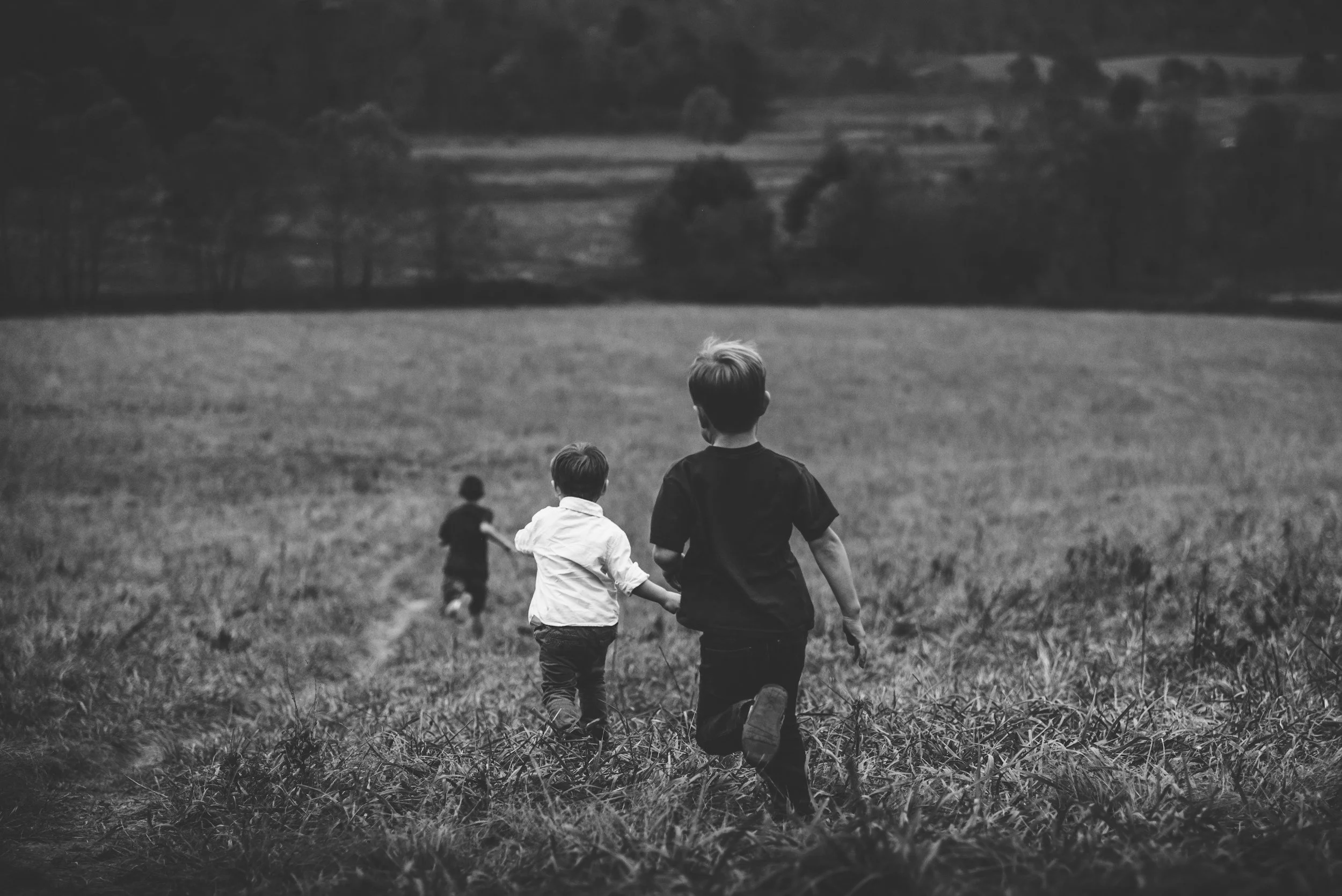 three children running in a open field