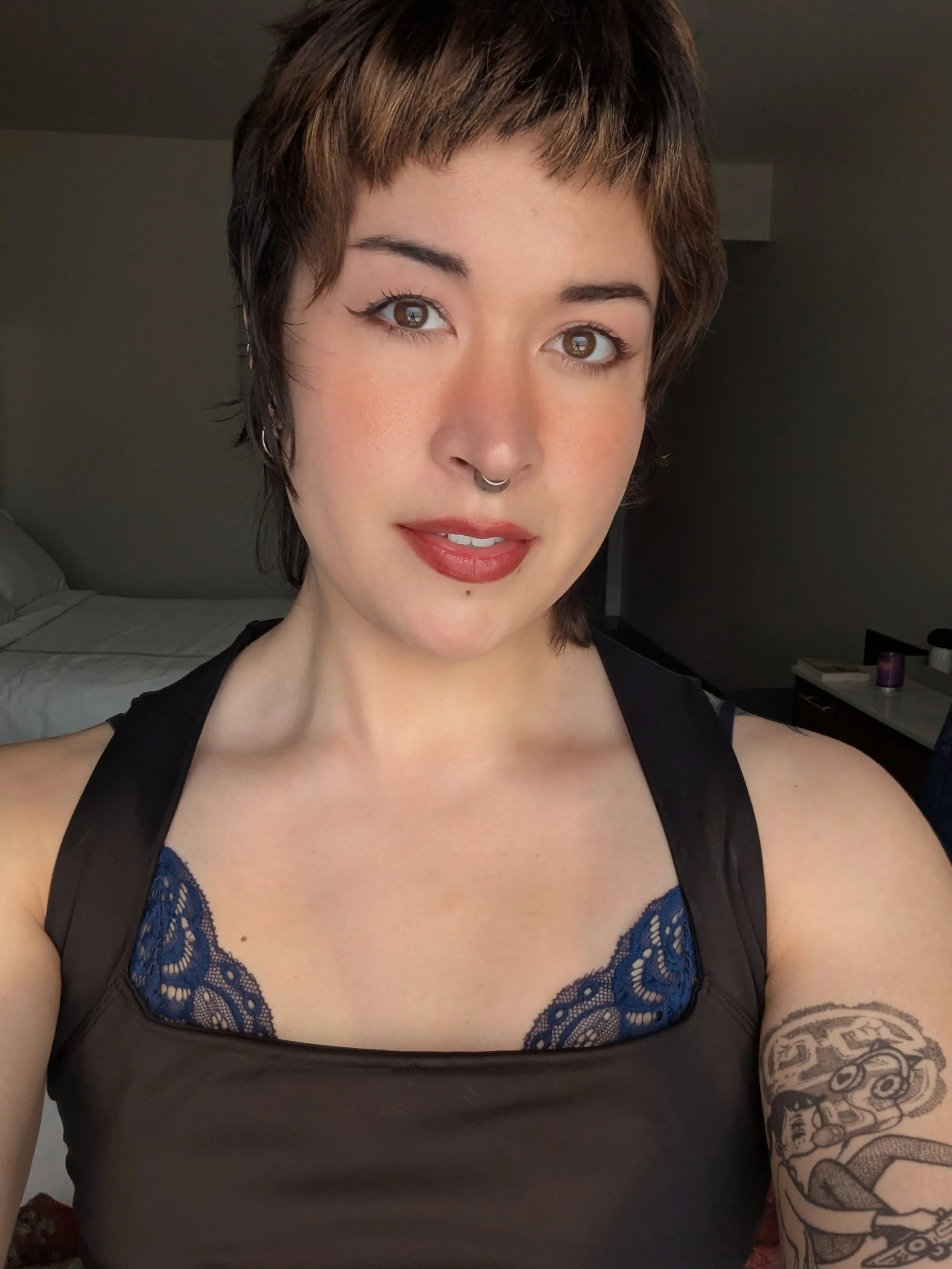 A sultry close-up portrait of blushing Thorne Vo with a blue lace bralette peeking above the neckline of her dress.