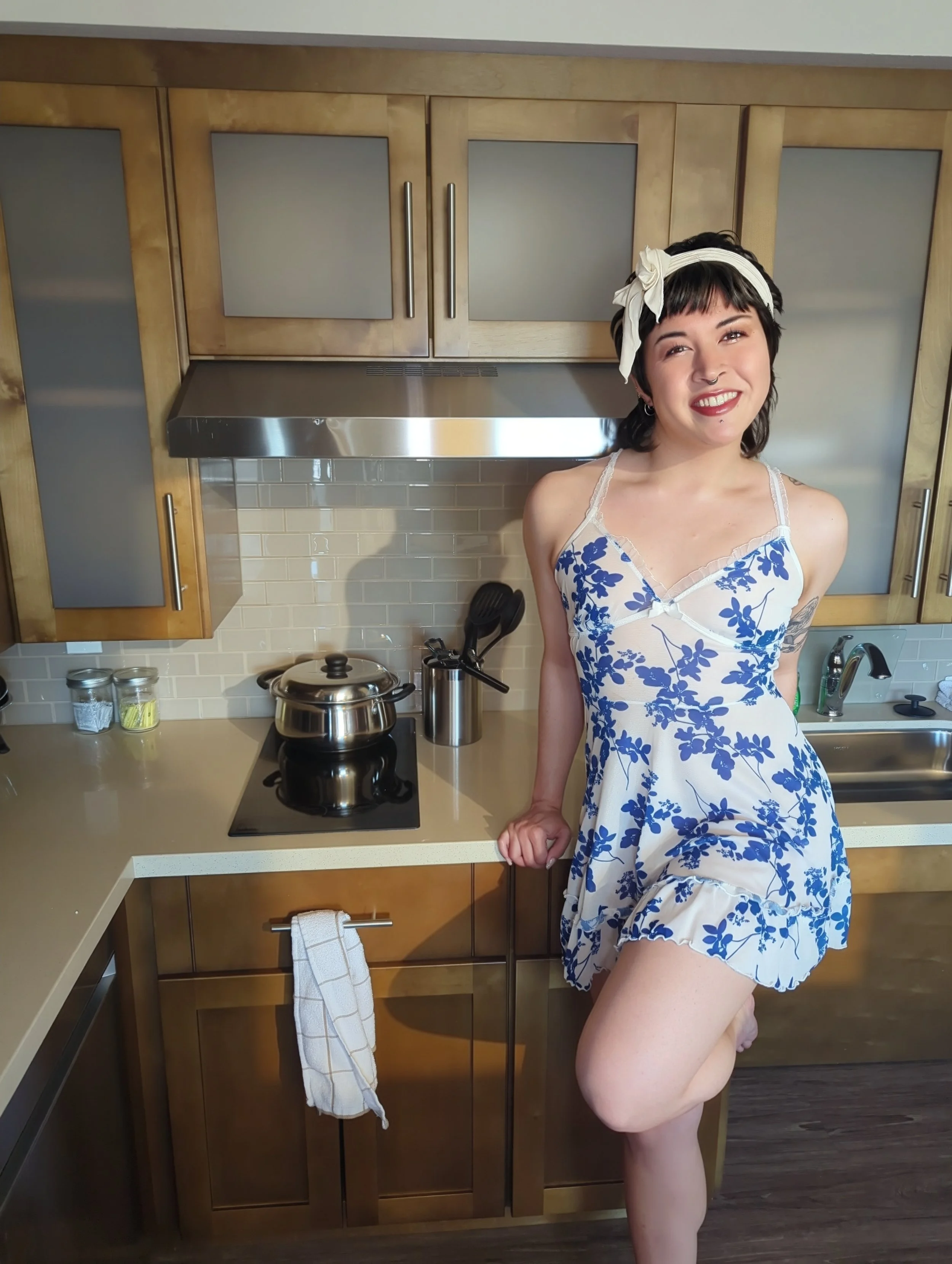 Thorne Vo Smiling in a blue floral dress in a modal kitchen.