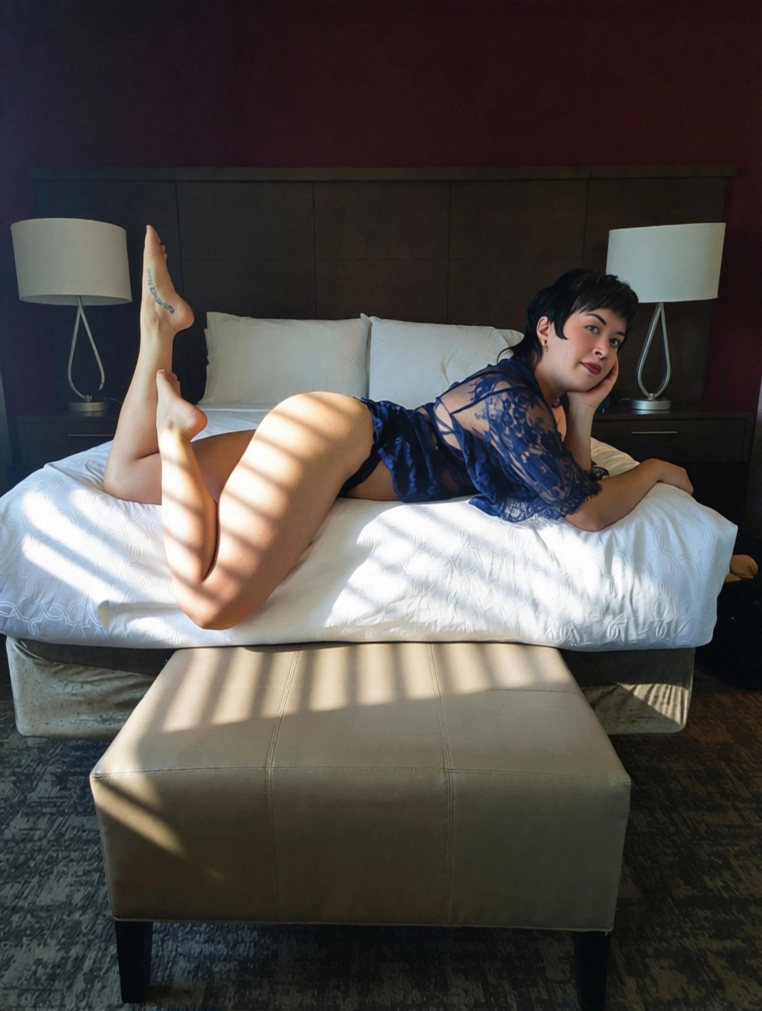 A photo of Thorne Vo reclined on the bed with sunlight from the window clinging to her hips.