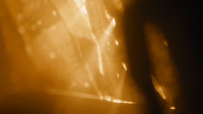 A blurry, golden-colored scene with bright lights and indistinct objects.