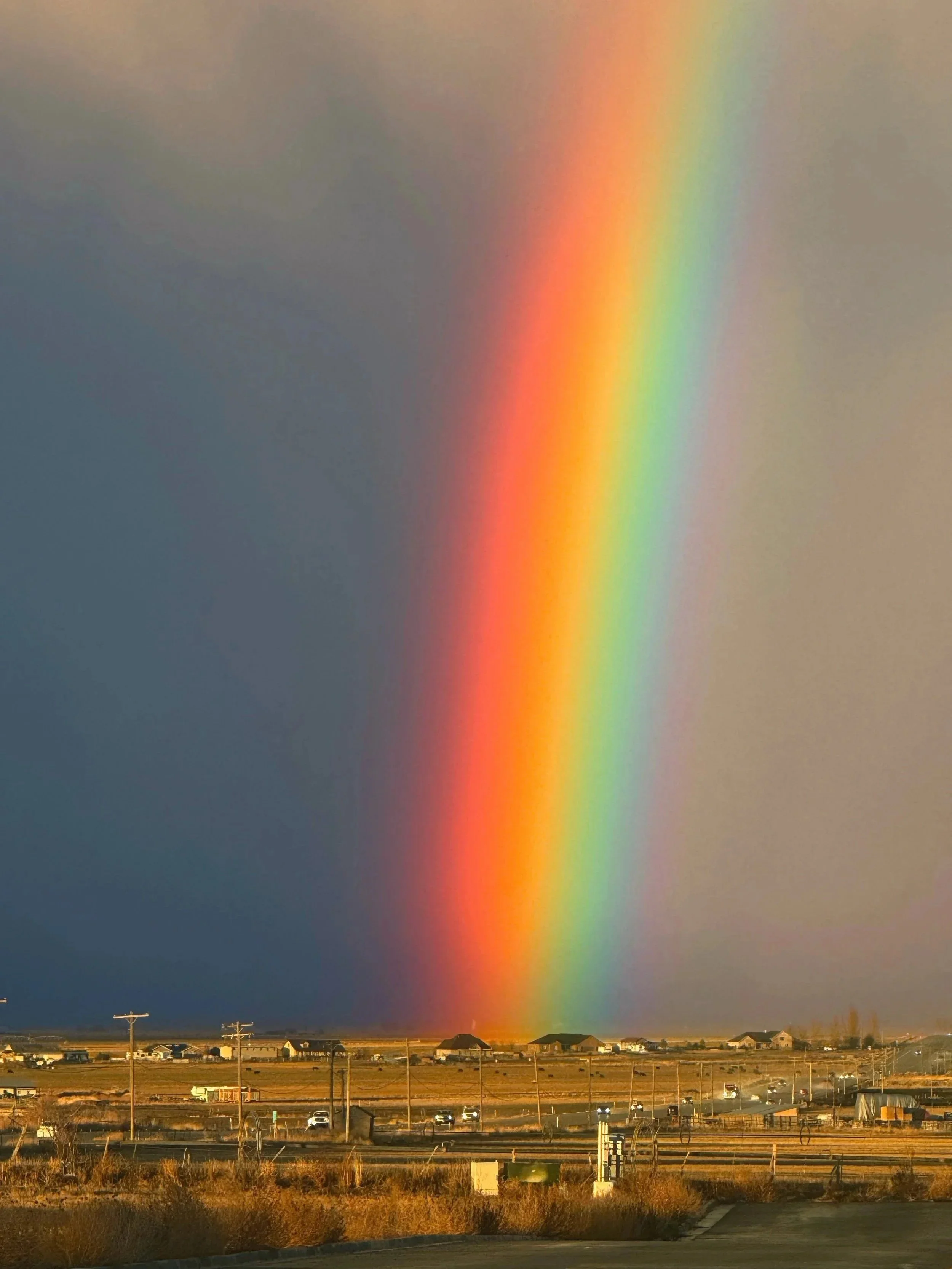 A vibrant rainbow over the rural landscape of Sanpete County, Utah, near Manti Temple View Estates.