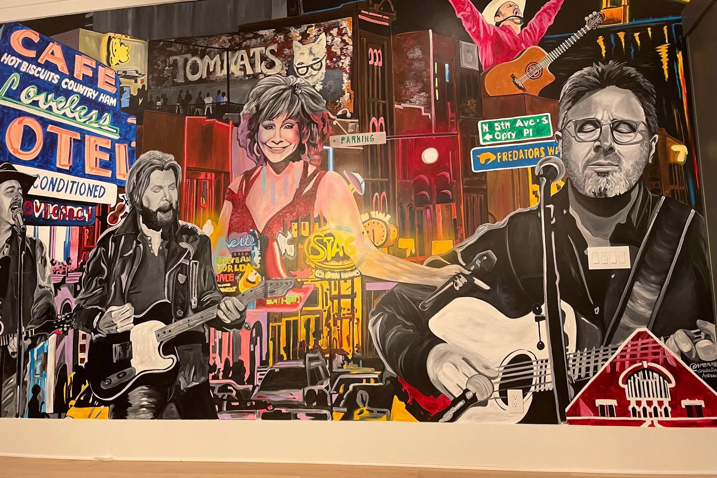 A vibrant mural depicting a city street scene with musicians playing guitars and a woman smiling, surrounded by neon signs, street signs, and colorful buildings in an artistic style.