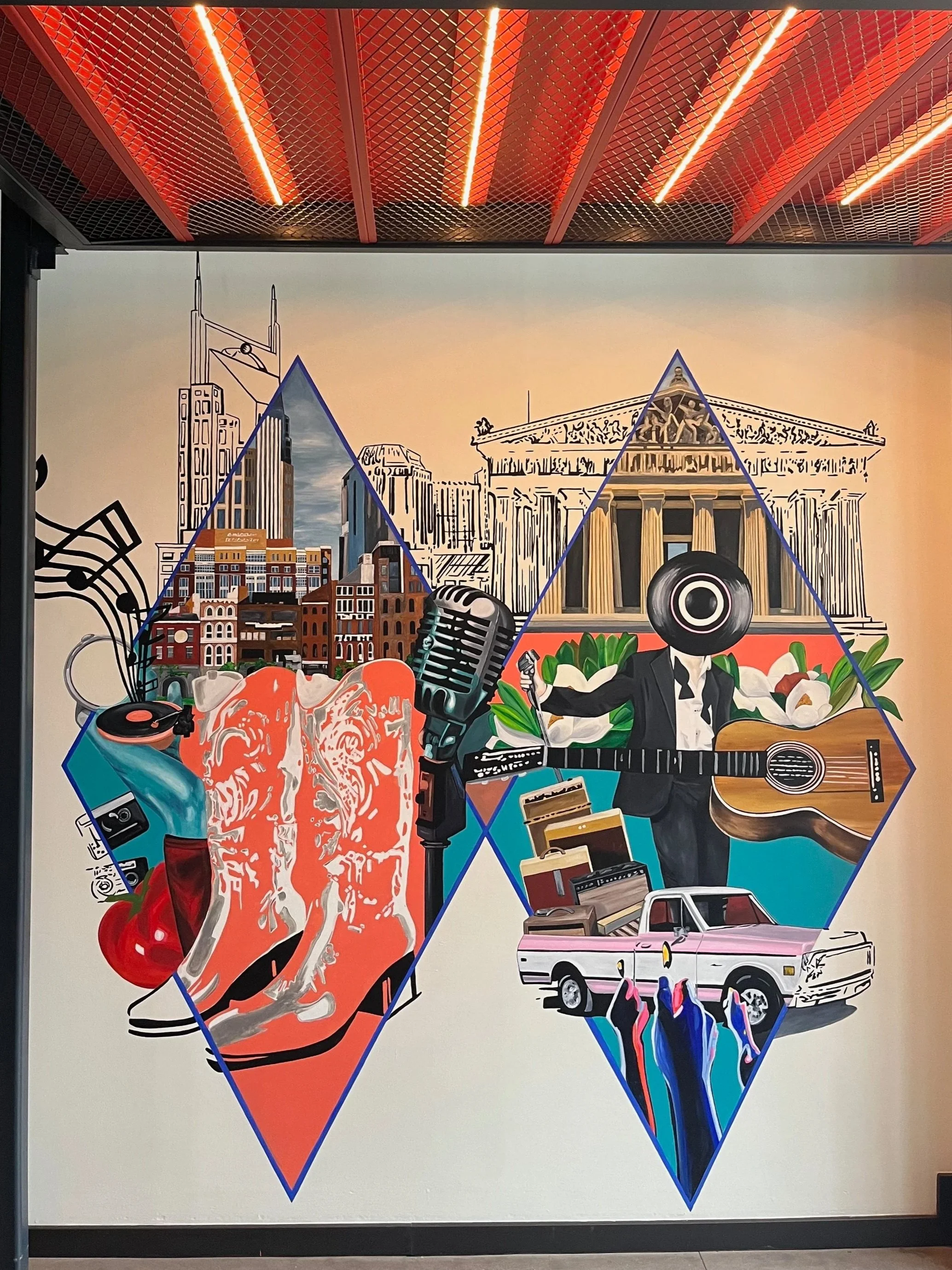 A colorful mural with various objects and cityscape background, featuring a city skyline, buildings, musical instruments, a vintage car, and stylized human figures within geometric shapes.
