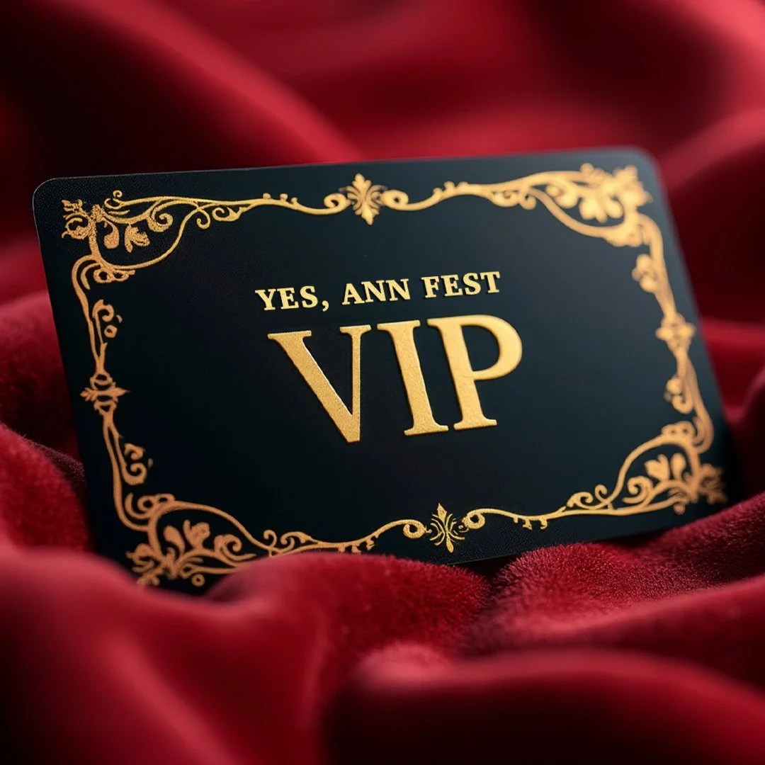 A black VIP card with gold ornate border and text reading 'YES, ANN FEST VIP' resting on red velvet fabric.