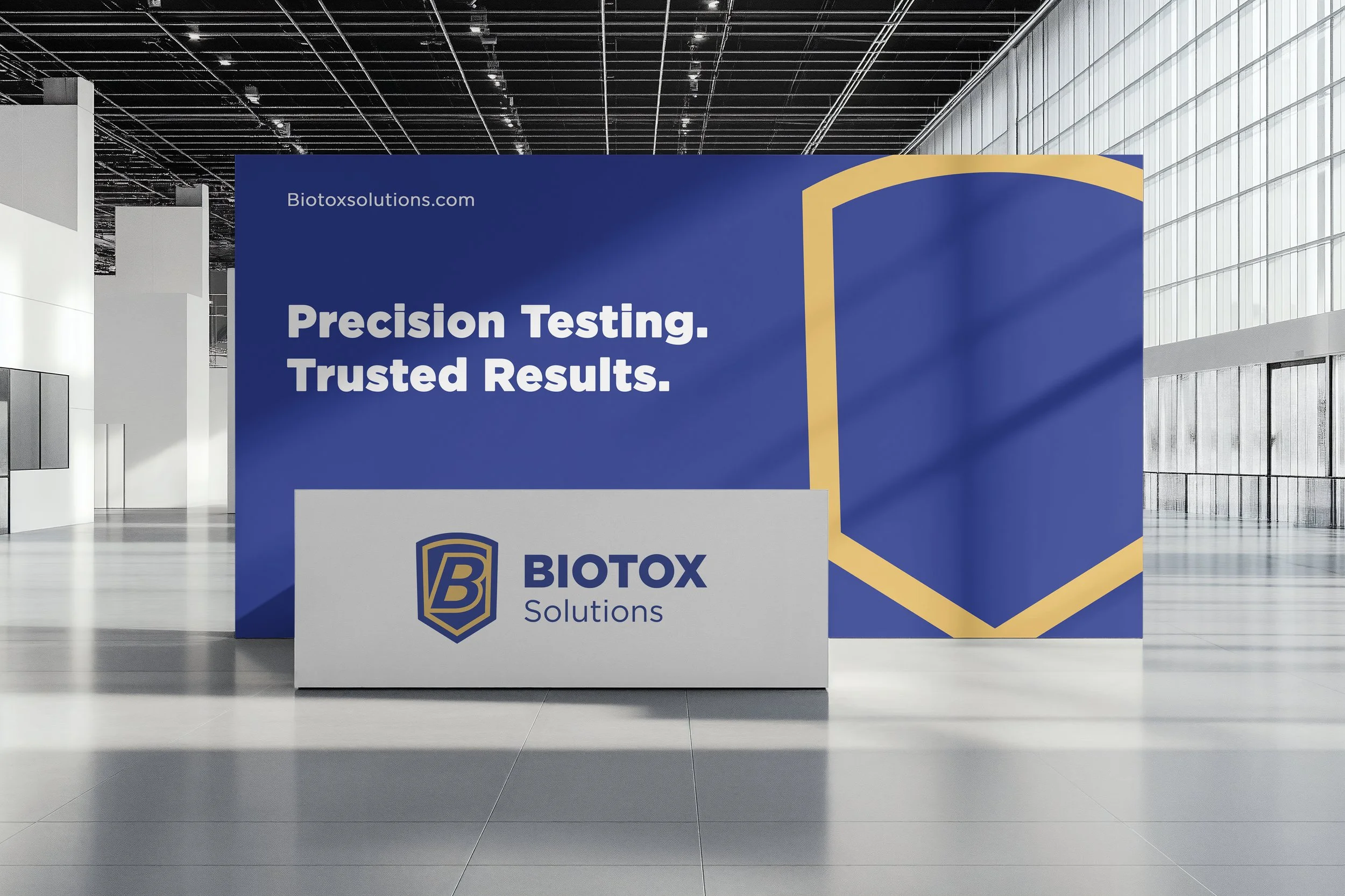 Trade show booth for Biotox Solutions with a large blue backdrop displaying the slogan "Precision Testing. Trusted Results." and the company logo on a white counter in front.