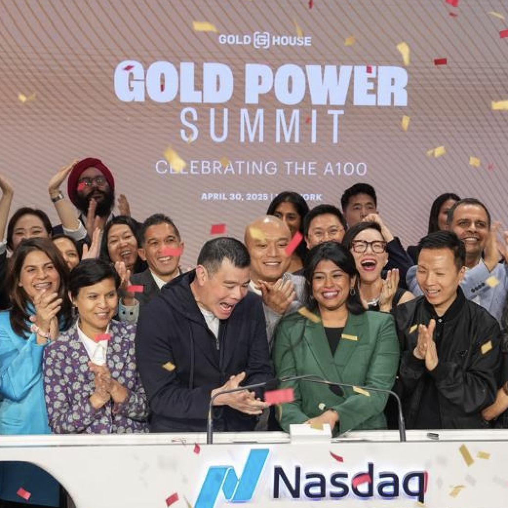 A group of diverse people celebrating at the Nasdaq, with a large screen behind them displaying 'Gold Power Summit' and the date April 30, 2023, amid confetti.