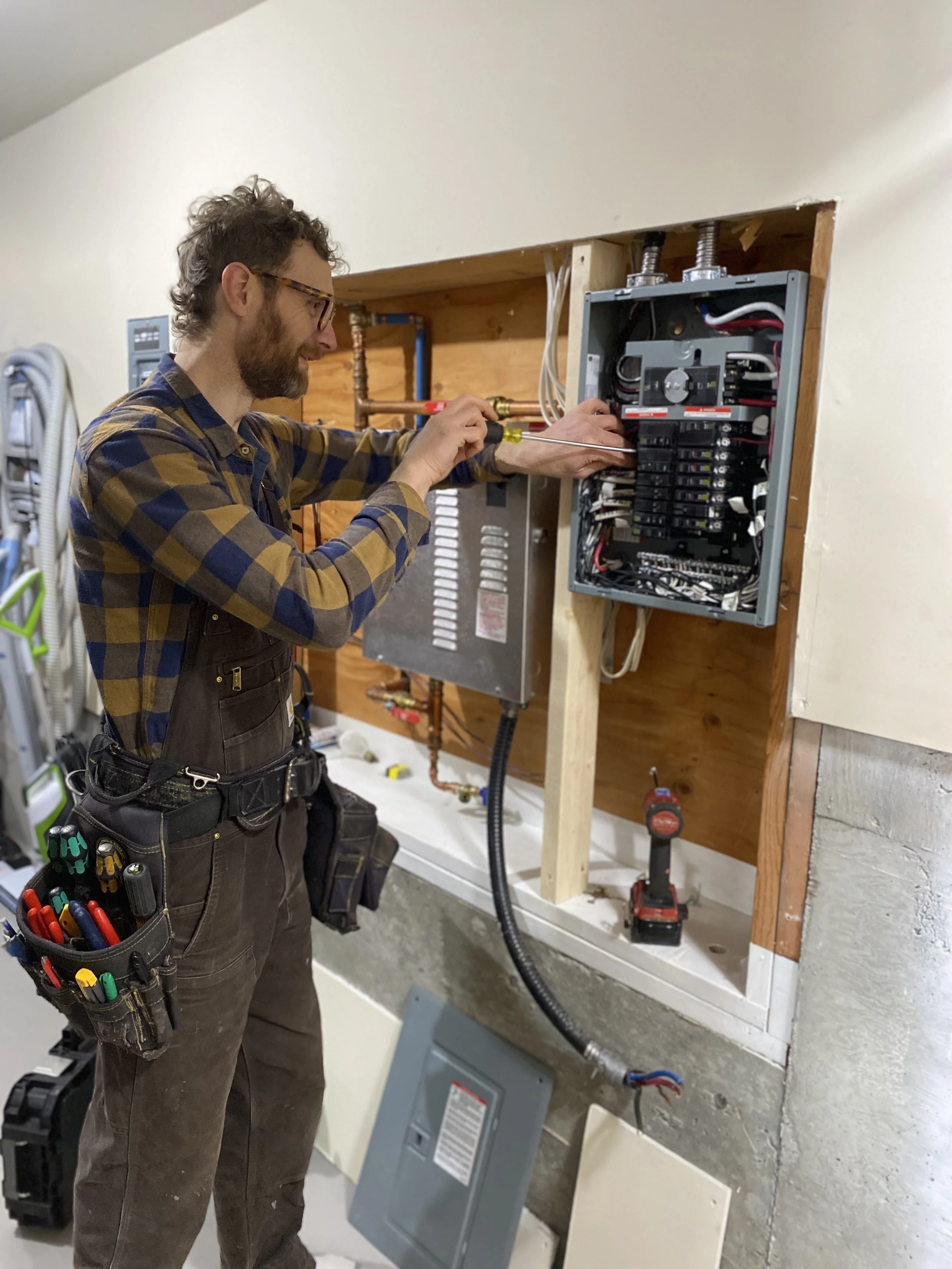 Professionele elektricien controleert aansluitingen en bedrading in een uitgebreide elektrische verdeelkast
