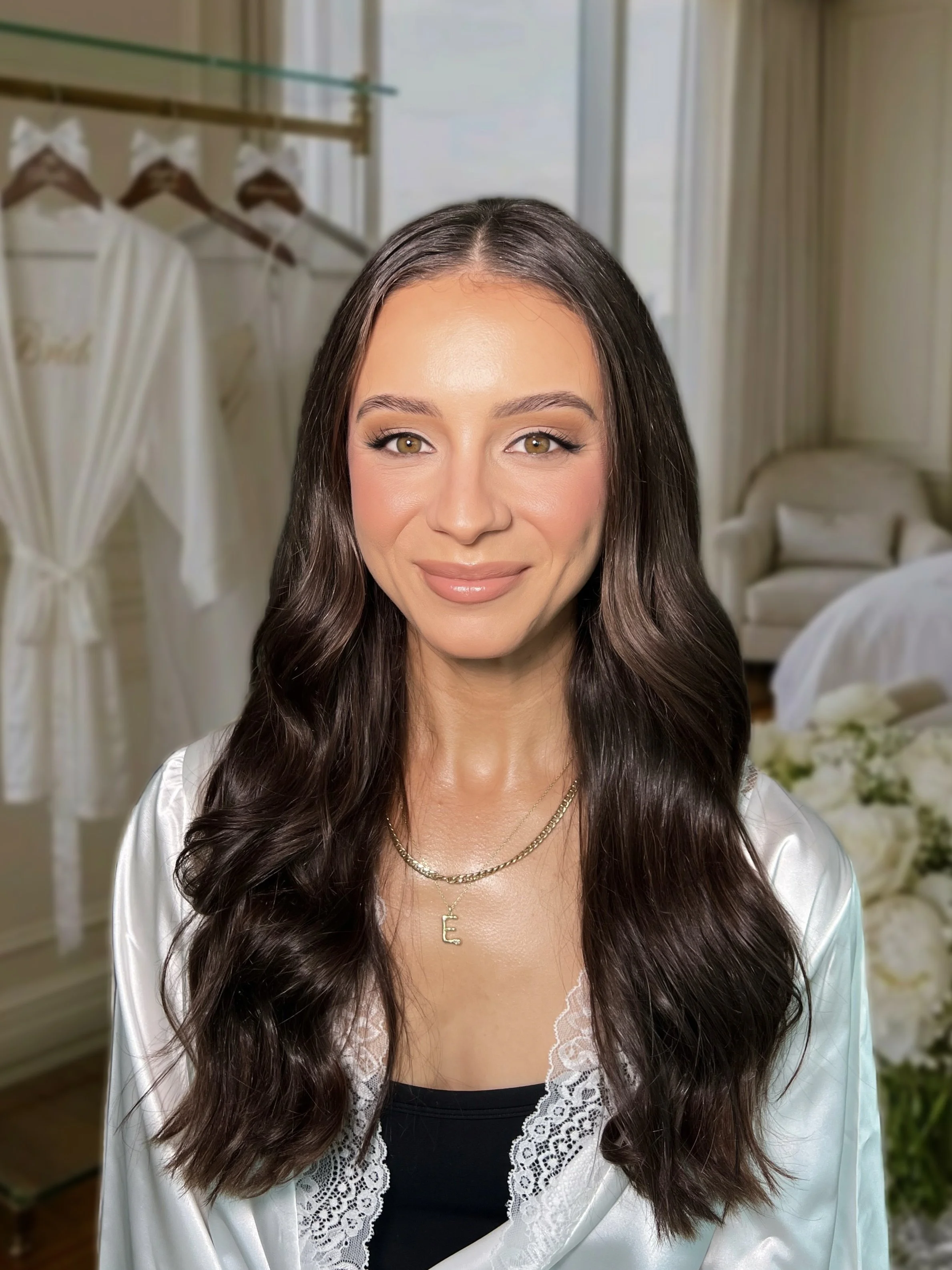 Bride in a lace-trim satin robe with layered necklaces, getting ready for her wedding-day makeup with Anastasia, Melbourne bridal makeup artist.