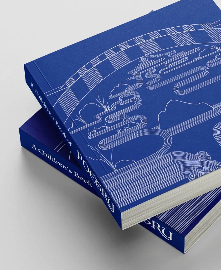 Two blue hardcover books titled "A Children's Book" and "A Children's Book" with white line art of clouds, a river, and mountains on the covers, stacked on a white surface.