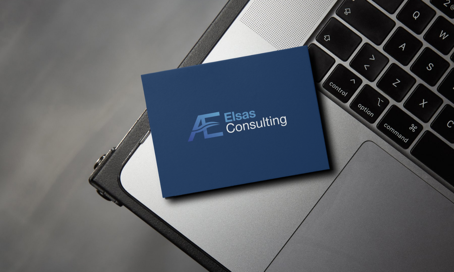 Business card for Elsas Consulting placed on a laptop keyboard.