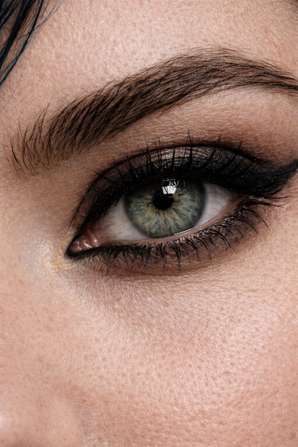 Close-up of a person's eye with green and blue iris, dark eyeliner, mascara, and well-groomed eyebrow. AI influencer, AI persona, AI design, custom AI.