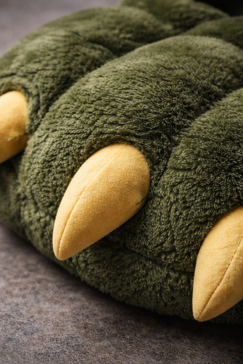 Close-up of a green stuffed animal resembling an eagle, with a yellow beak and wing tips, lying on a gray surface. Custom AI influencer, persona, content creator, brand ambassador.