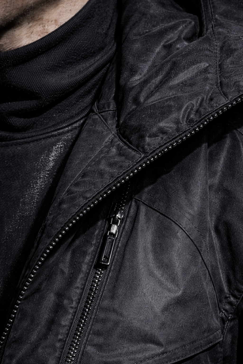 Close-up of a black leather jacket with a zipper, worn over a black shirt or turtleneck.  Custom AI Influencer, AI persona.