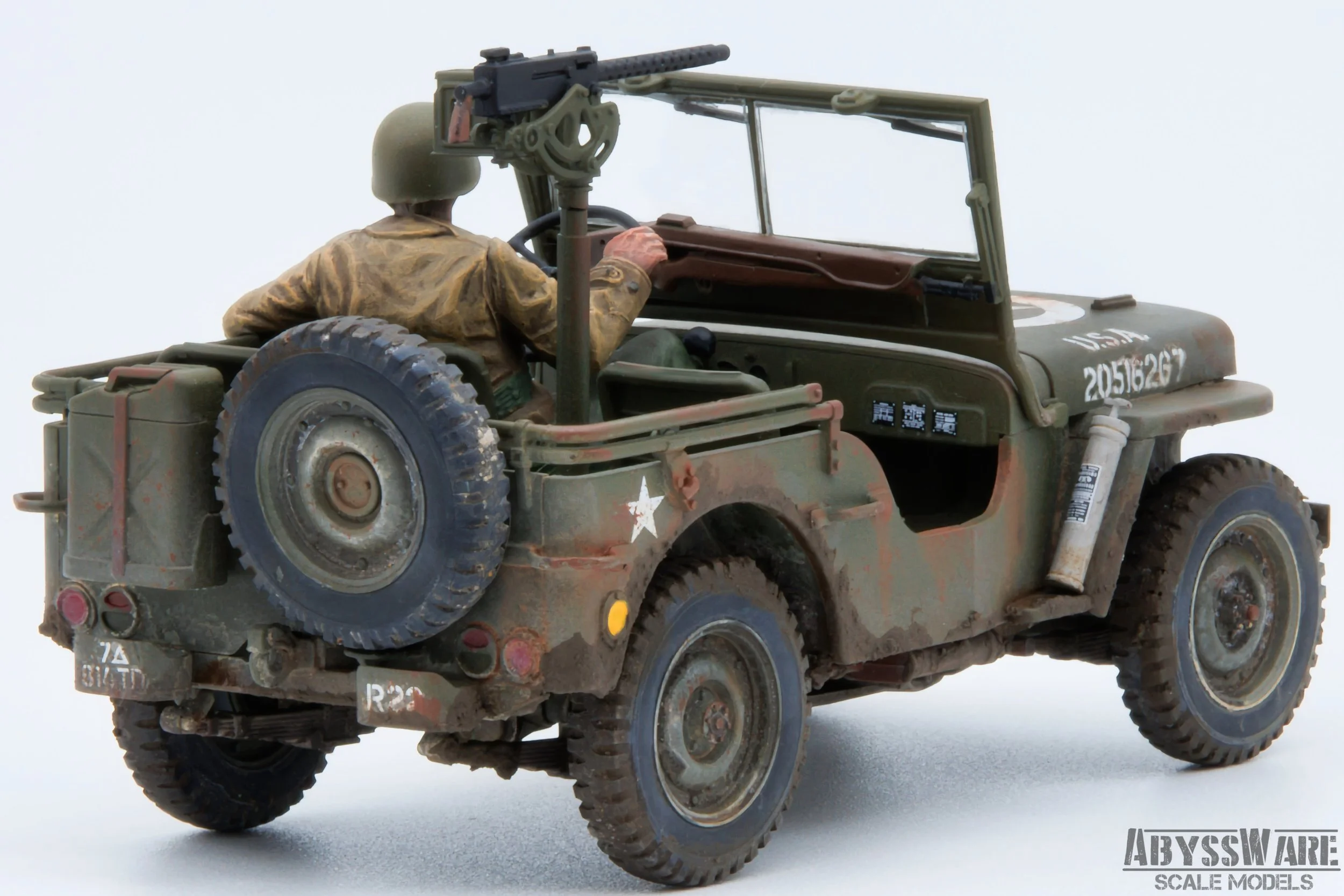 A detailed scale model of a military jeep with a soldier figure driving. The jeep is weathered and has the U.S. Army markings, a spare tire on the back, and a mounted machine gun on the passenger side.