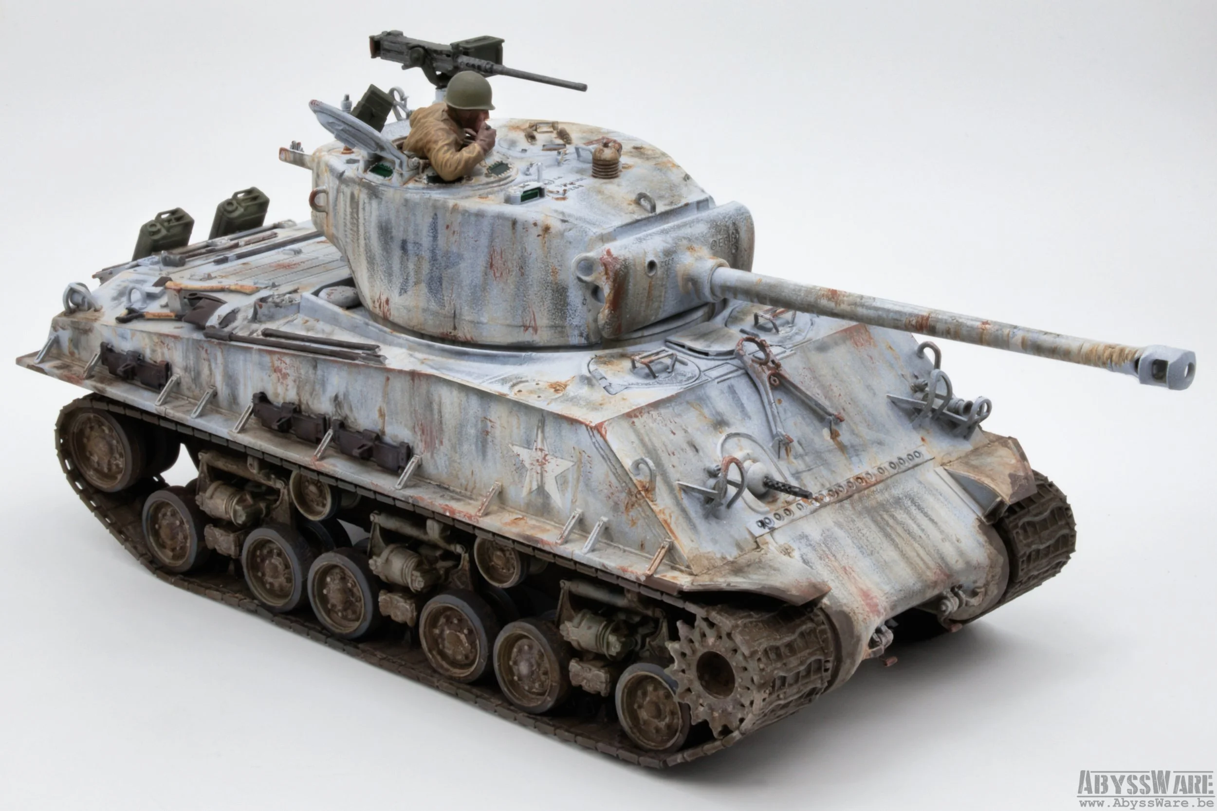 Model of a weathered military tank with a soldier figure in the turret, displaying rust, dirt, and paint details, on a plain orange background.