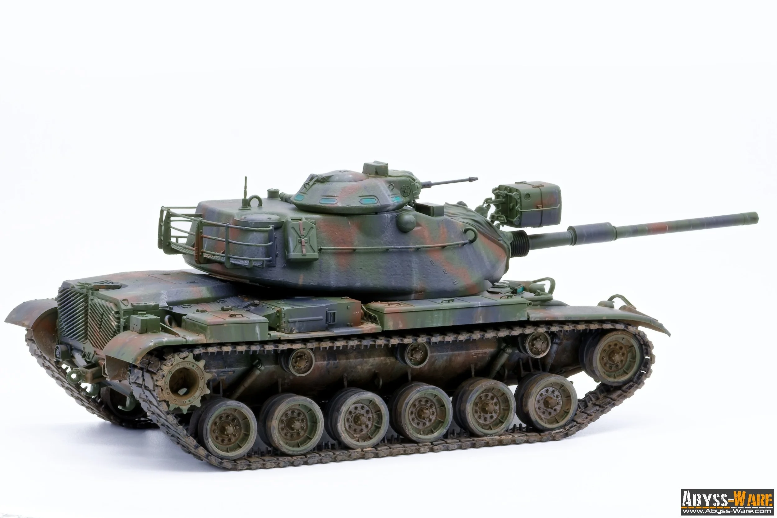Model of a military tank with a camouflage pattern, featuring a long barrel and detailed treads, set against a white background.