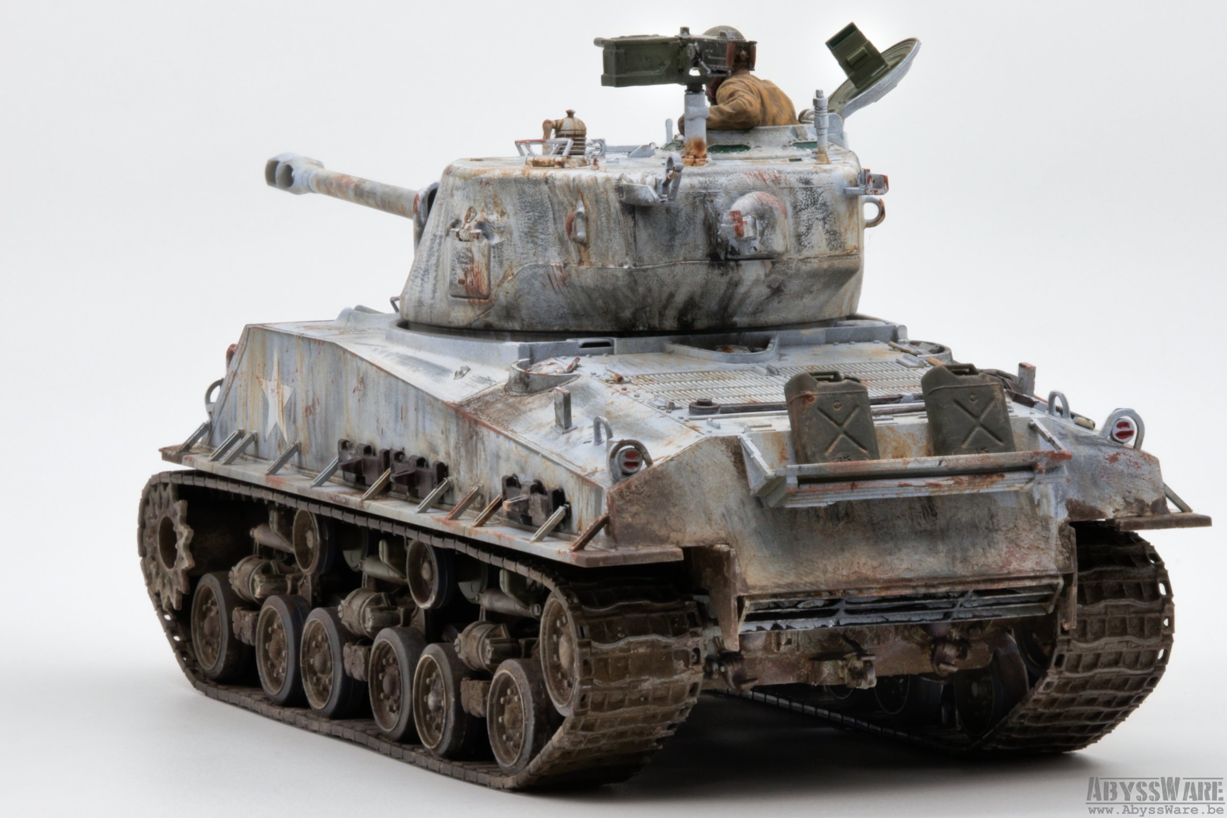 Model of a weathered military tank with a soldier figure in the turret, set against a plain white background.