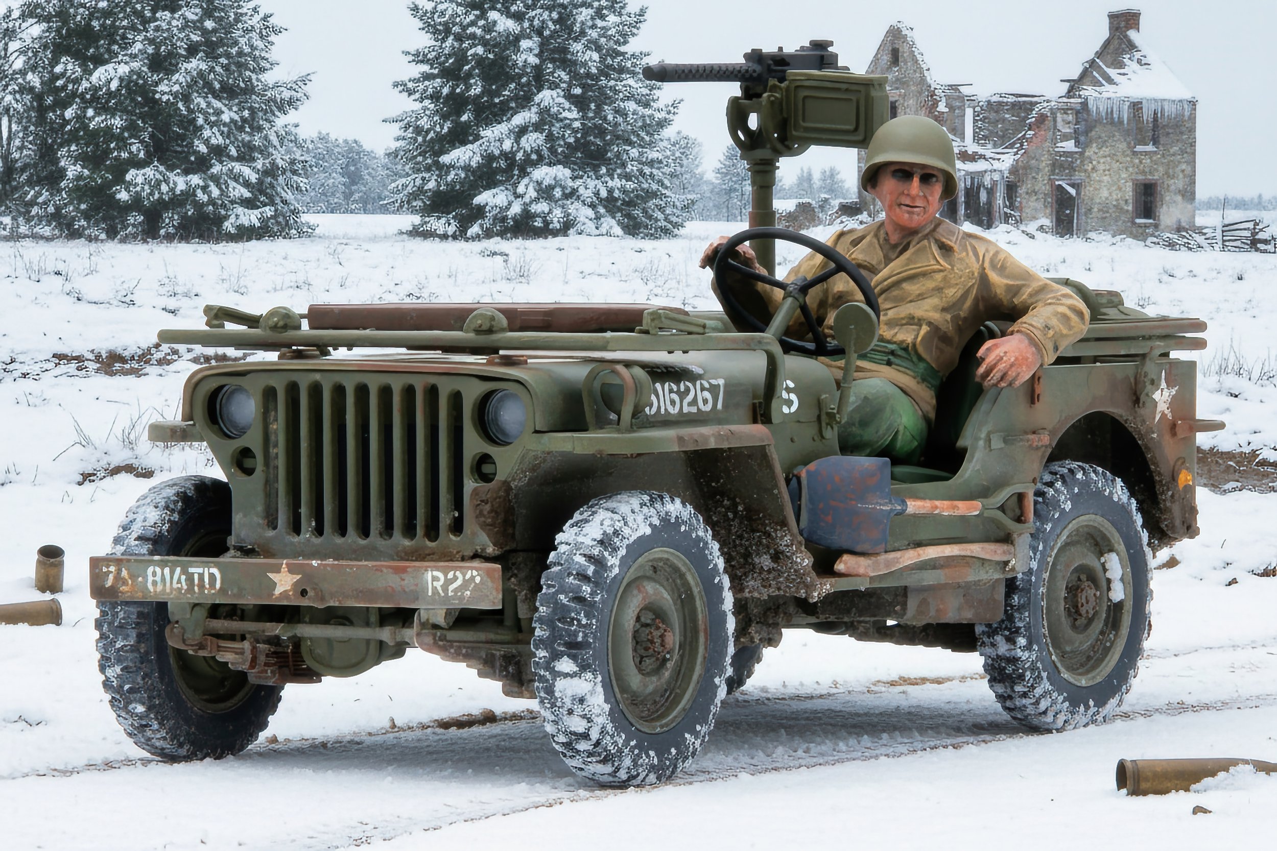 Diorama of a soldier sitting in a vintage military jeep during winter, with snowy landscape, trees, and an old house in the background.