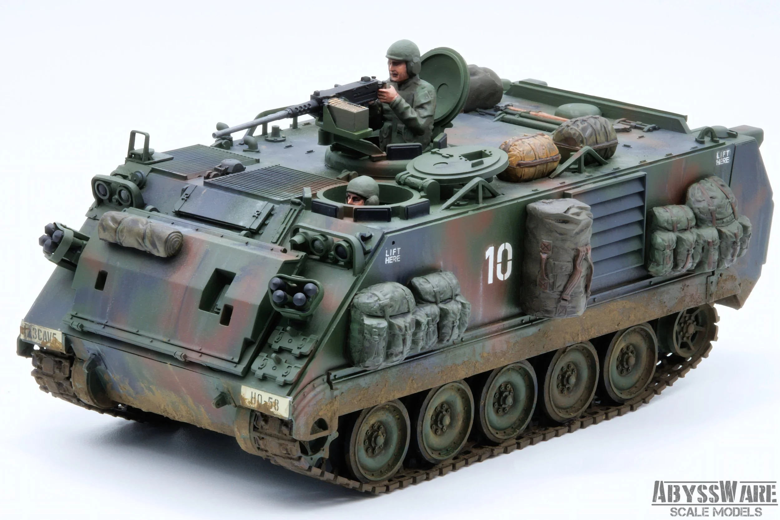 Scale model of a military armored vehicle with soldiers' figures, camouflage paint, and various equipment attached.