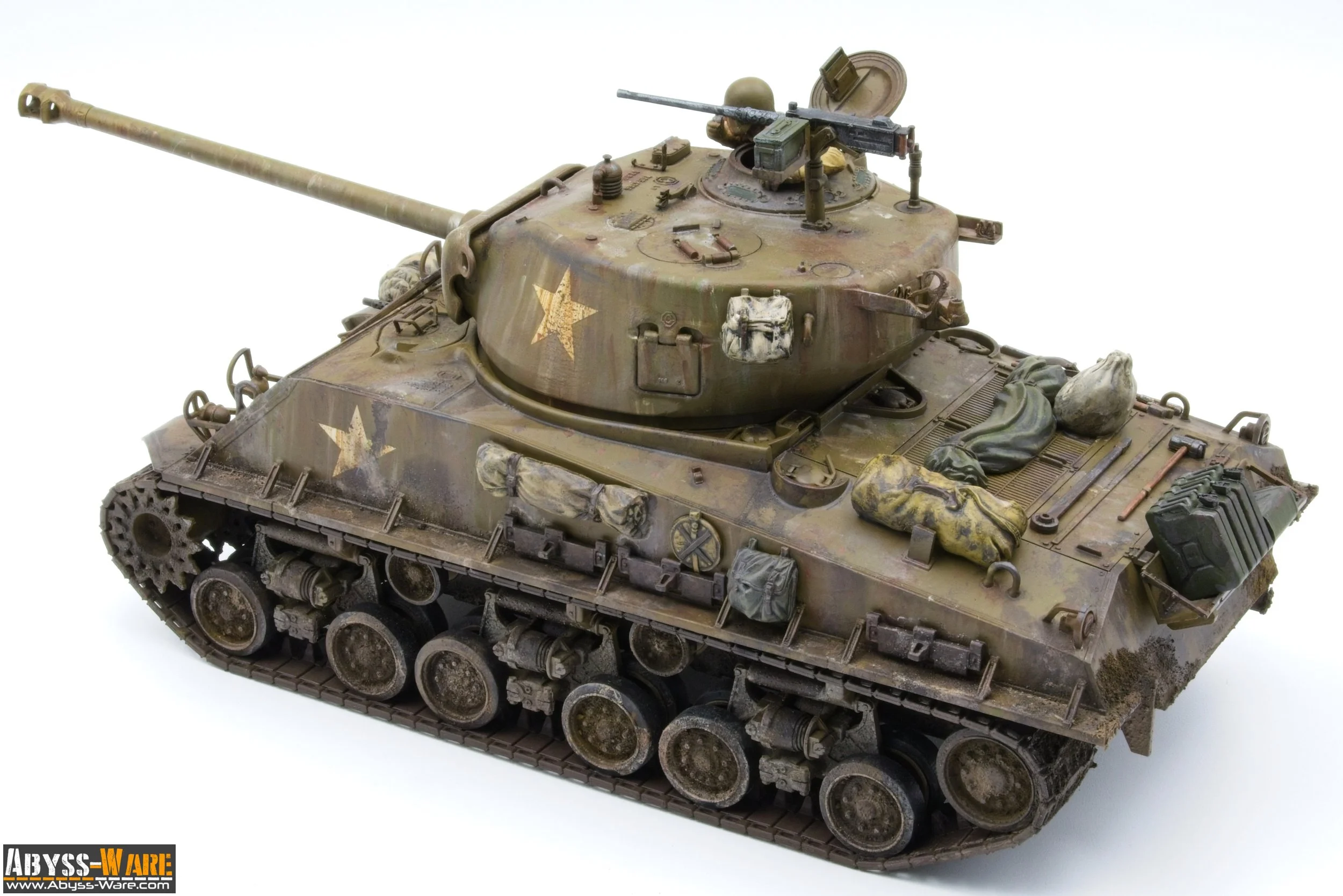 Model of a military tank with camouflage paint, mounted with a large gun barrel, cargo bags, and equipment, on a white background.