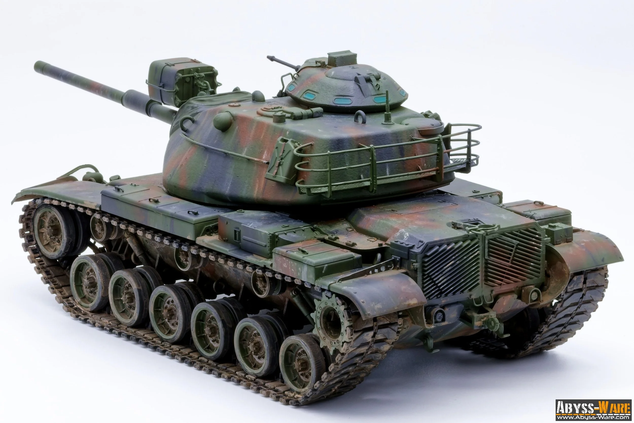 A detailed model of a military tank with a camouflage pattern, featuring a large gun barrel, tracks, and various accessories on a plain background.