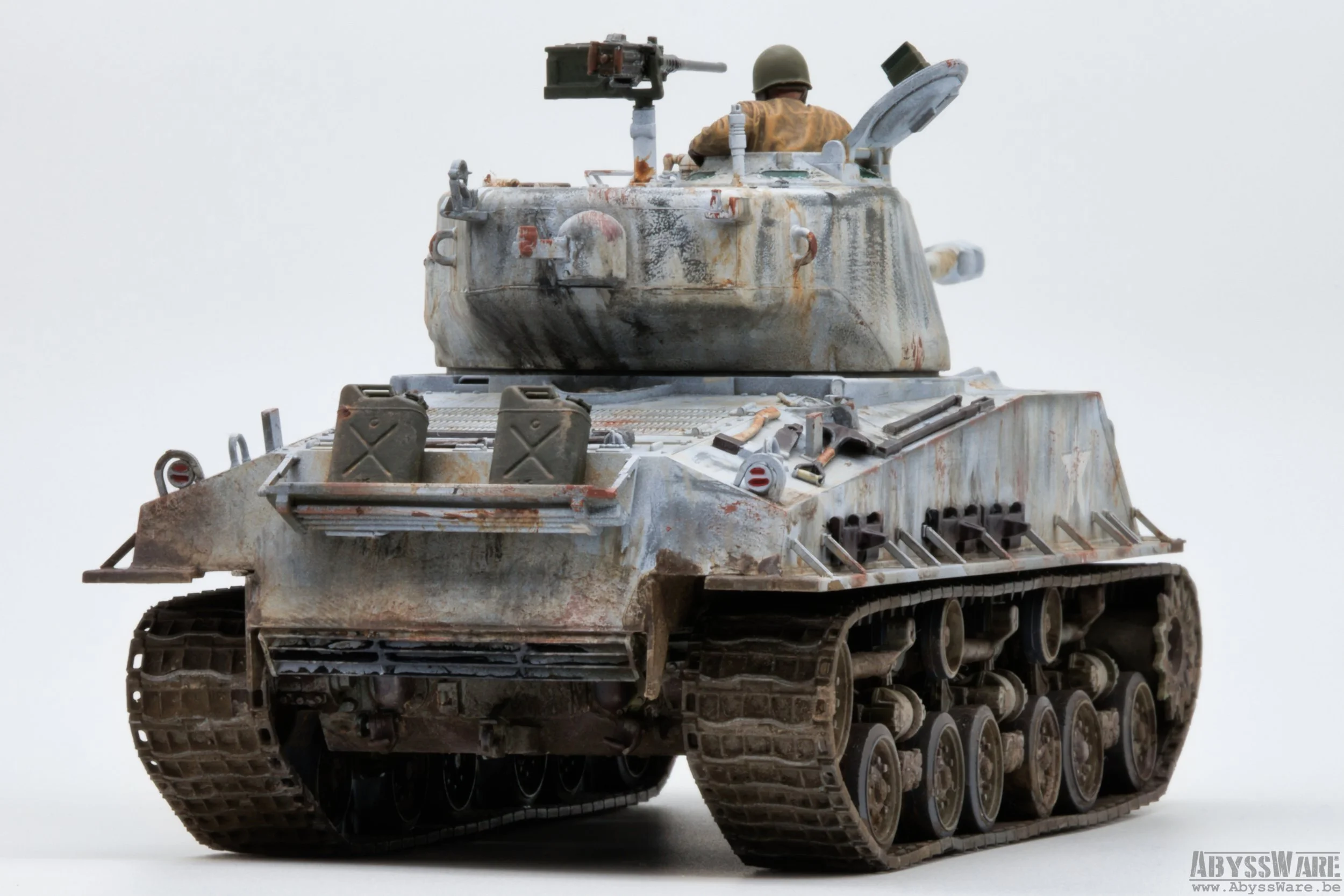 A detailed model of a weathered military tank with a soldier figure in the turret, on a plain light background.