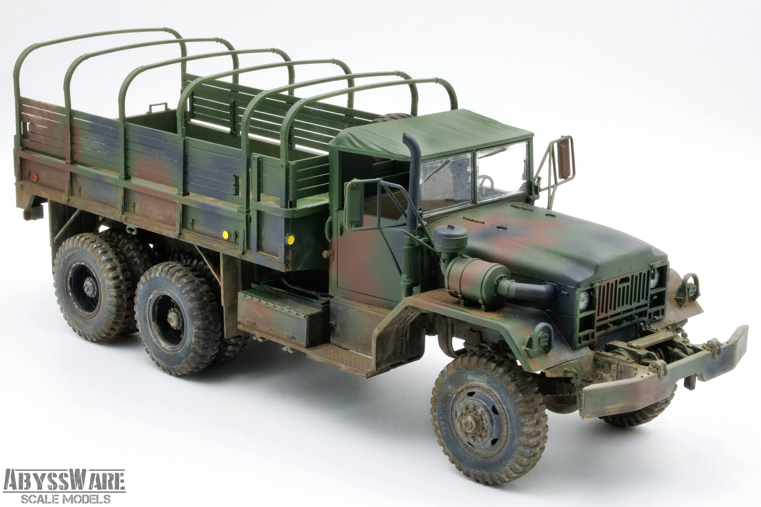 Scale model of a military cargo truck with a camouflage paint job, six large tires, a covered cargo bed, and detailed front and side view.